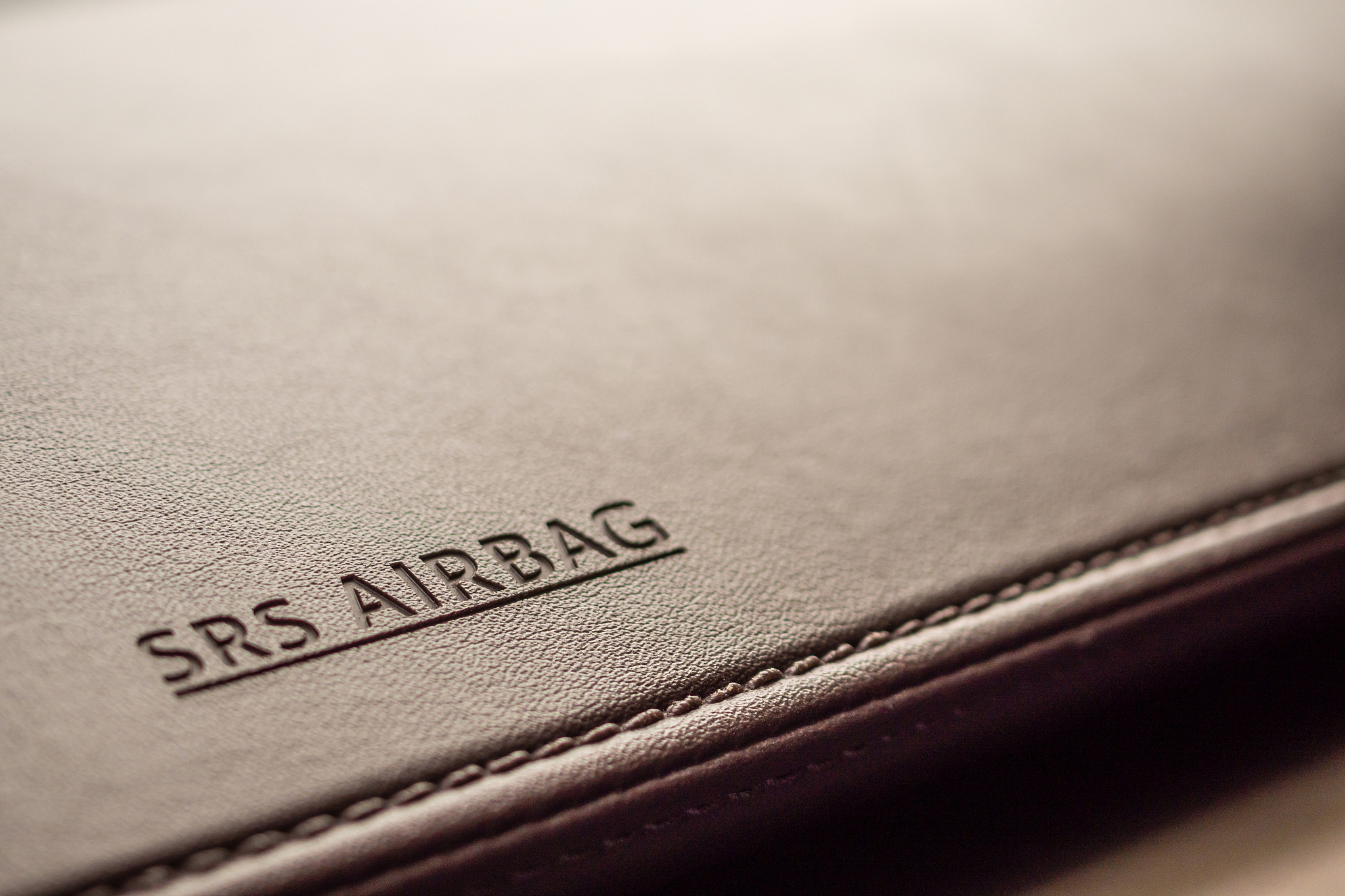 airbag safety sign on brown leather texture in modern car