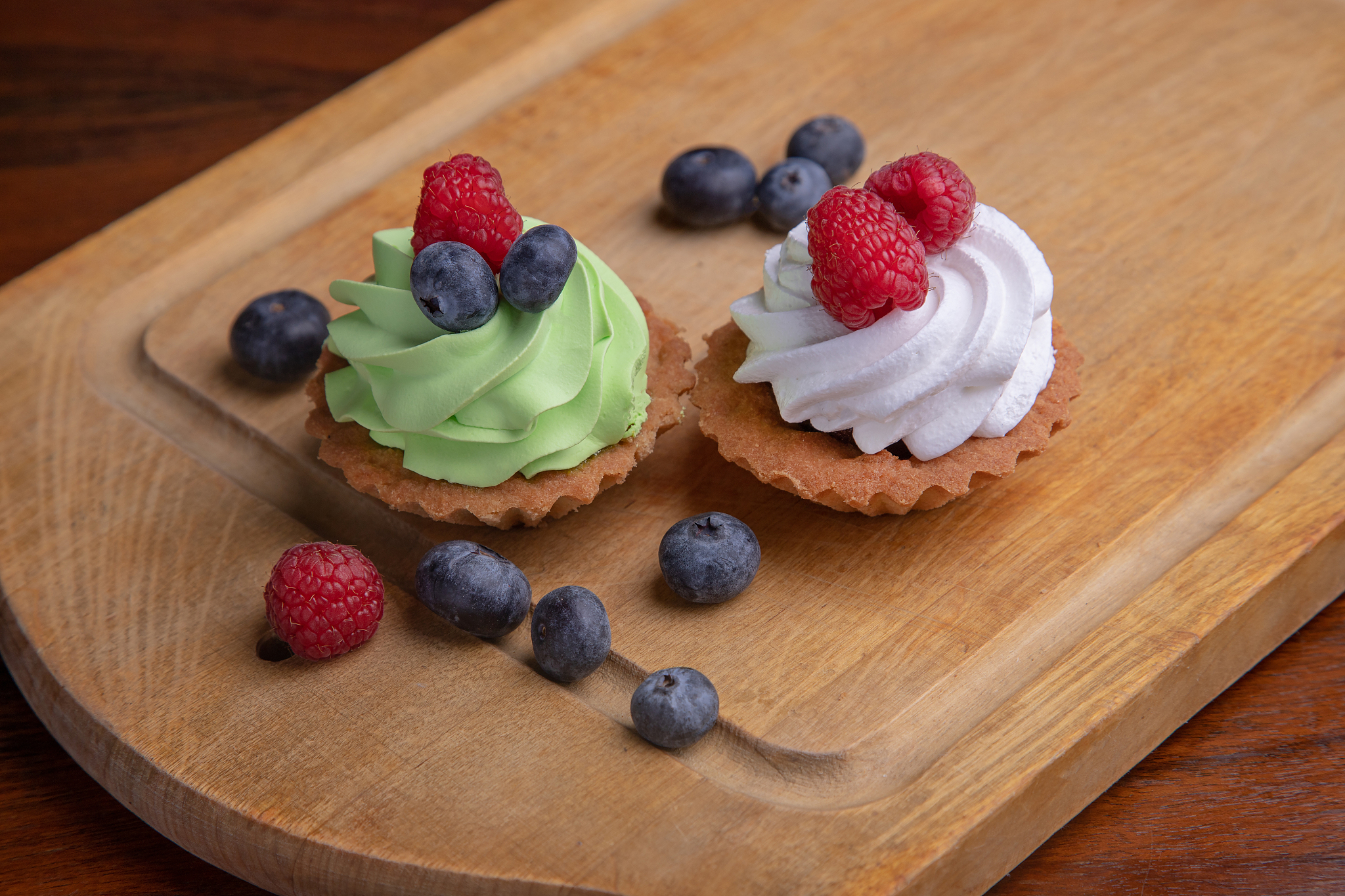 cream cake with berries on a wooden table