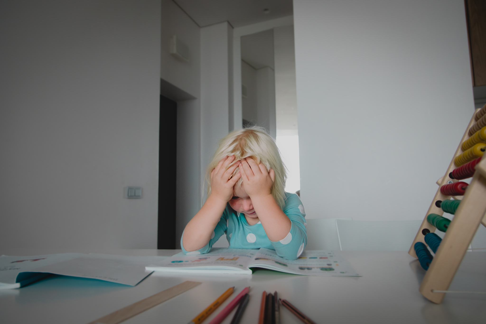 little girl tired and stressed of learning, doing homework
