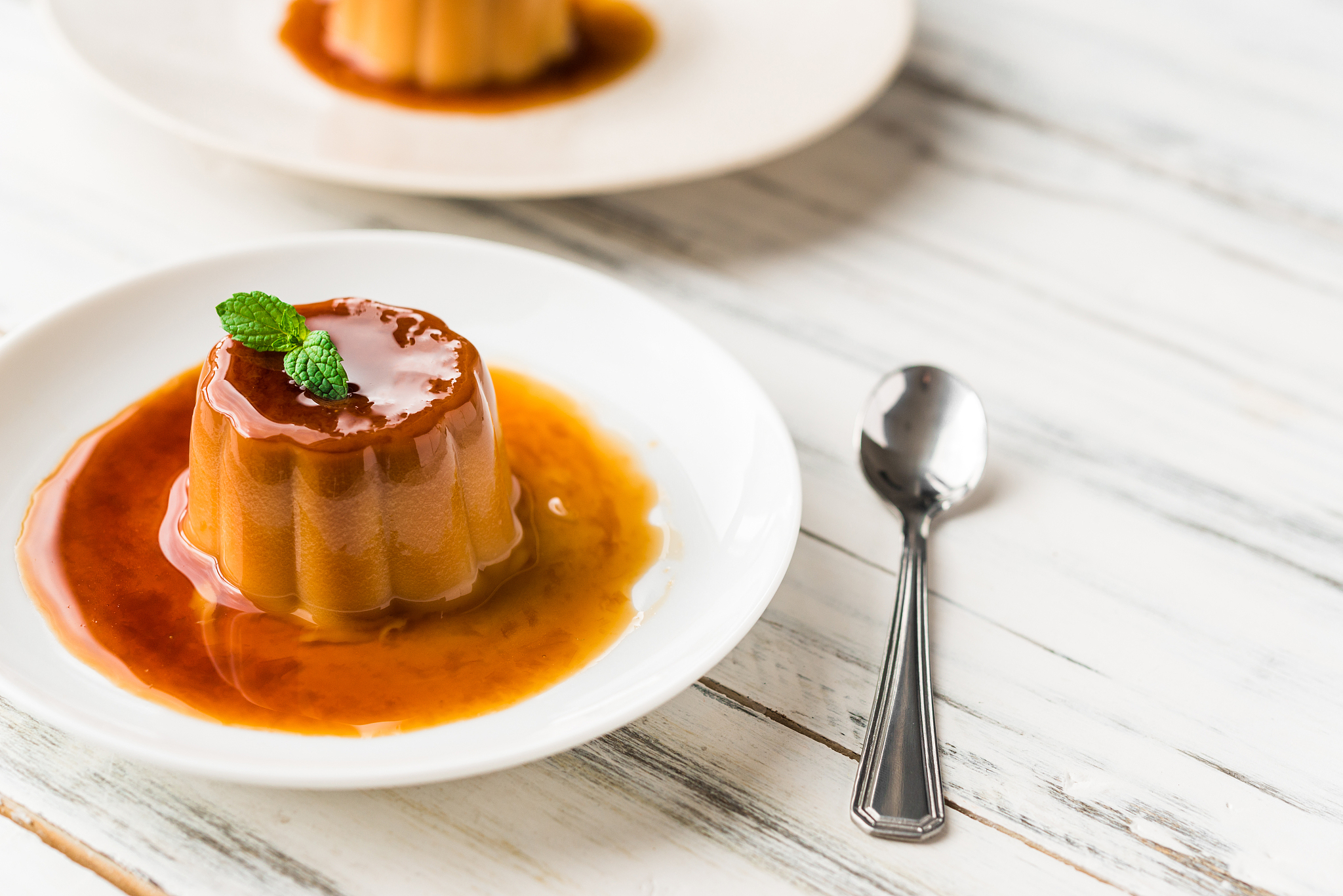 close up of a flan creme caramel pudding with mint, a custard de