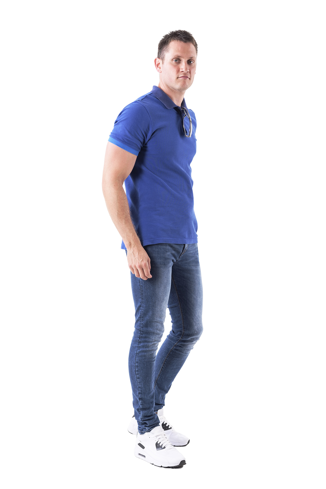 side view of relaxed young adult casual man walking with sunglas
