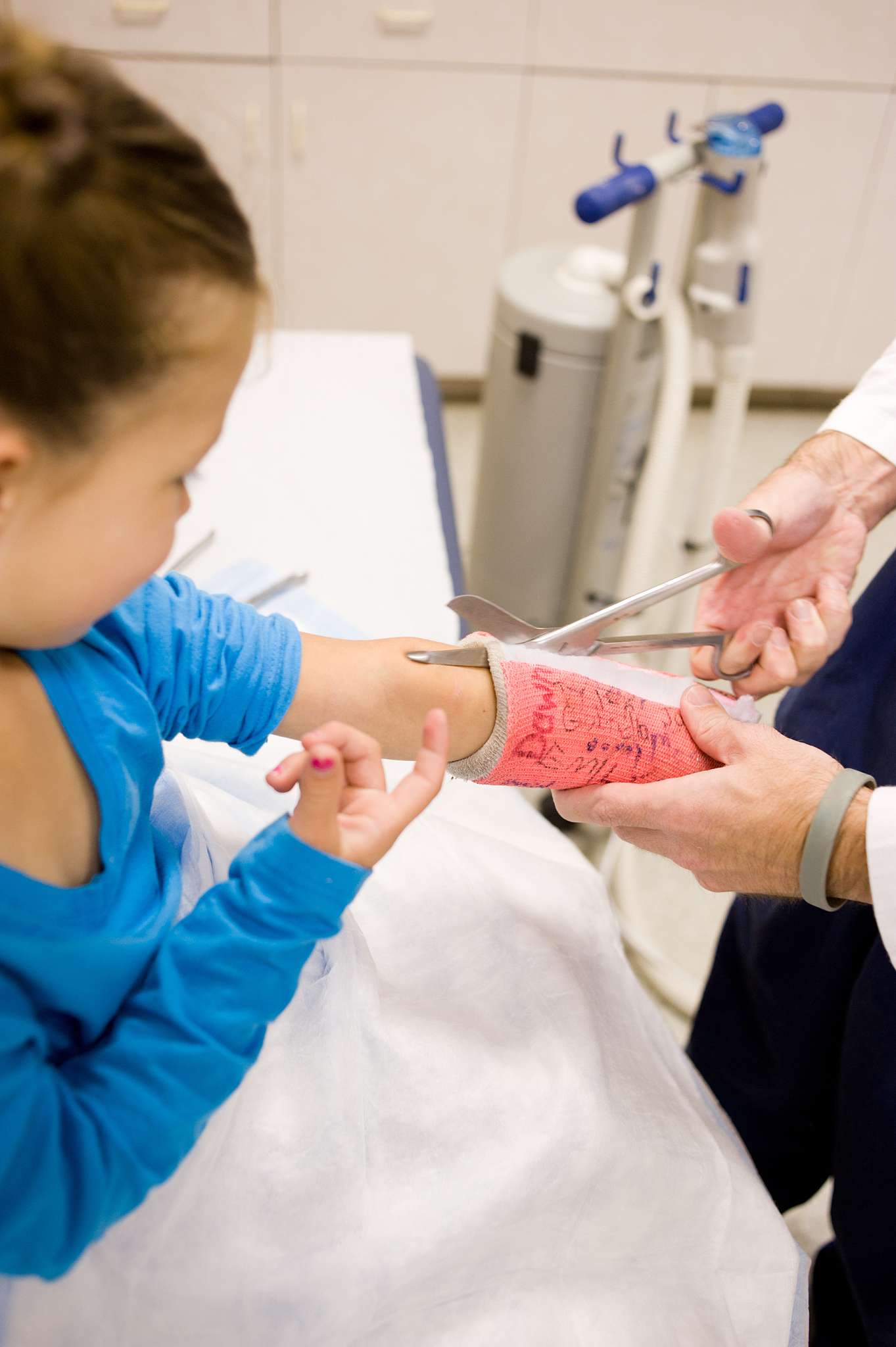 little girl watches as cast comes off broken arm (series)