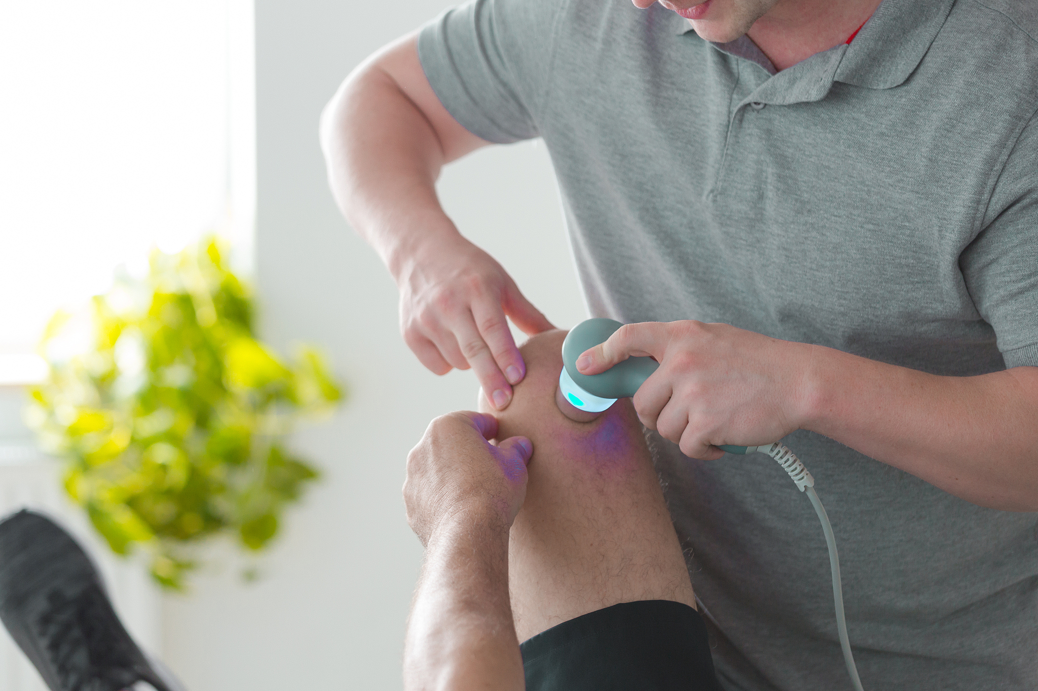 physiotherapist treating man with ultrasound