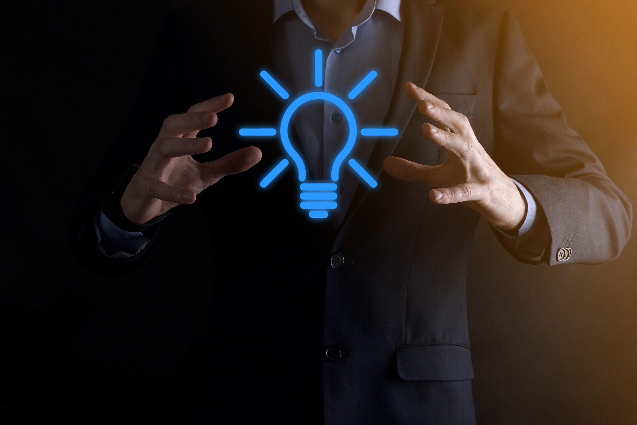 businessman in a suit with a light bulb in his hands. holds a gl