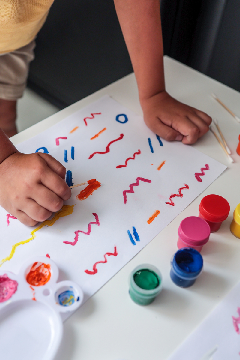 写一个游戏片段过程：幼儿自己动手把布放入花绷子上、用笔在白色的布上绘画好图案