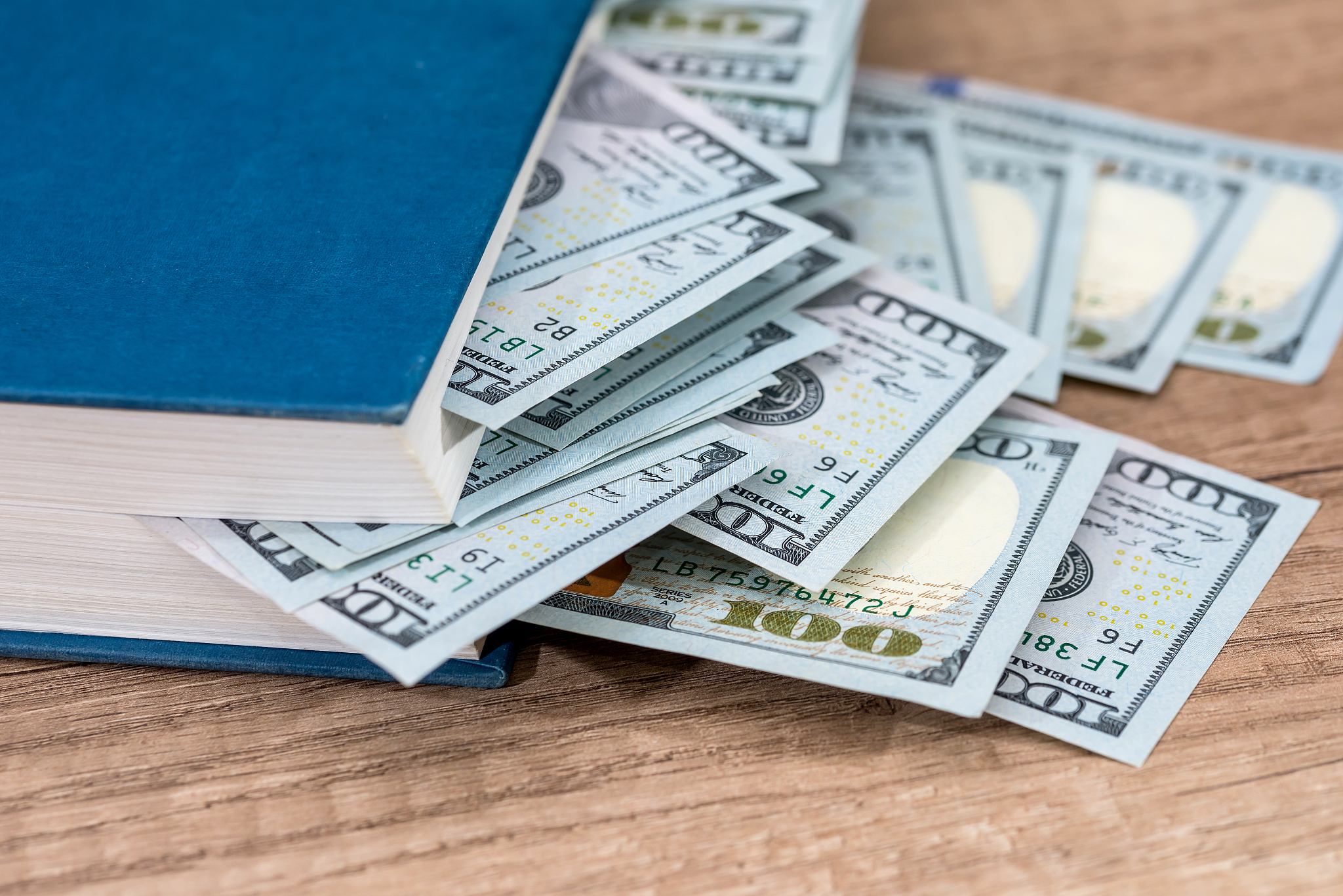 us 100 dollar in book on desk.