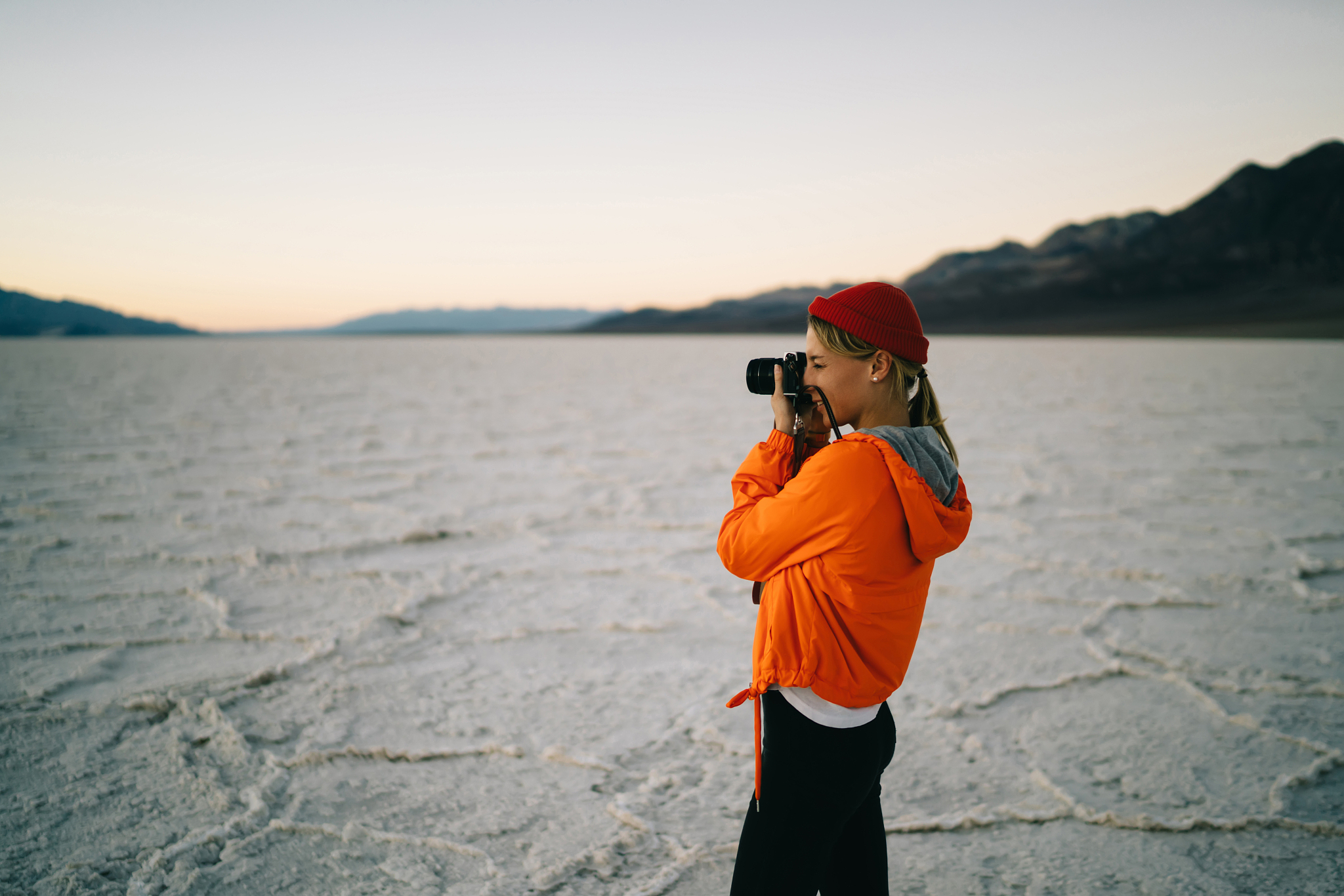 young female photographer making picture of scenic landscape on 