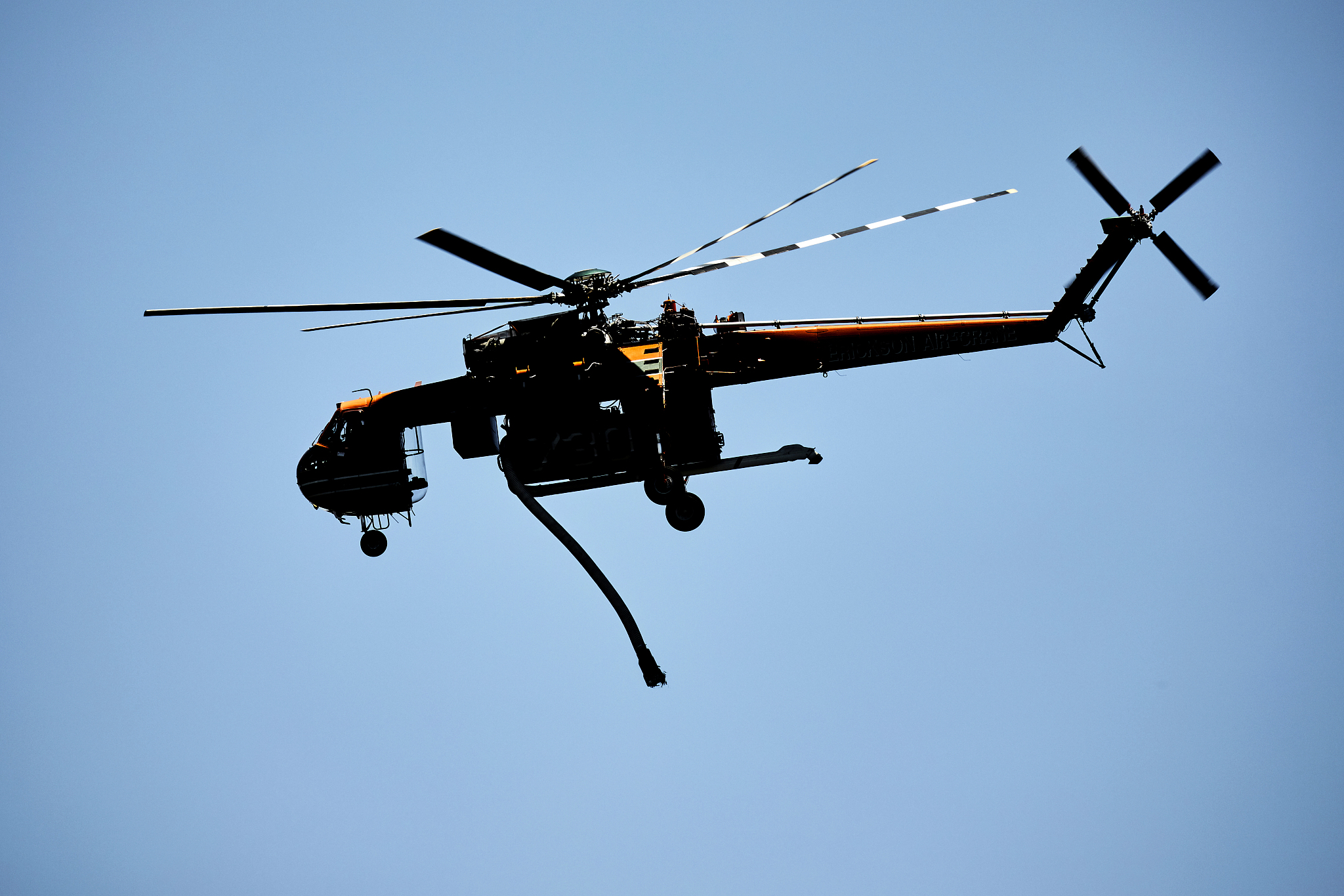 firefighting helicopter aircraft in silhouette with blue sky, au