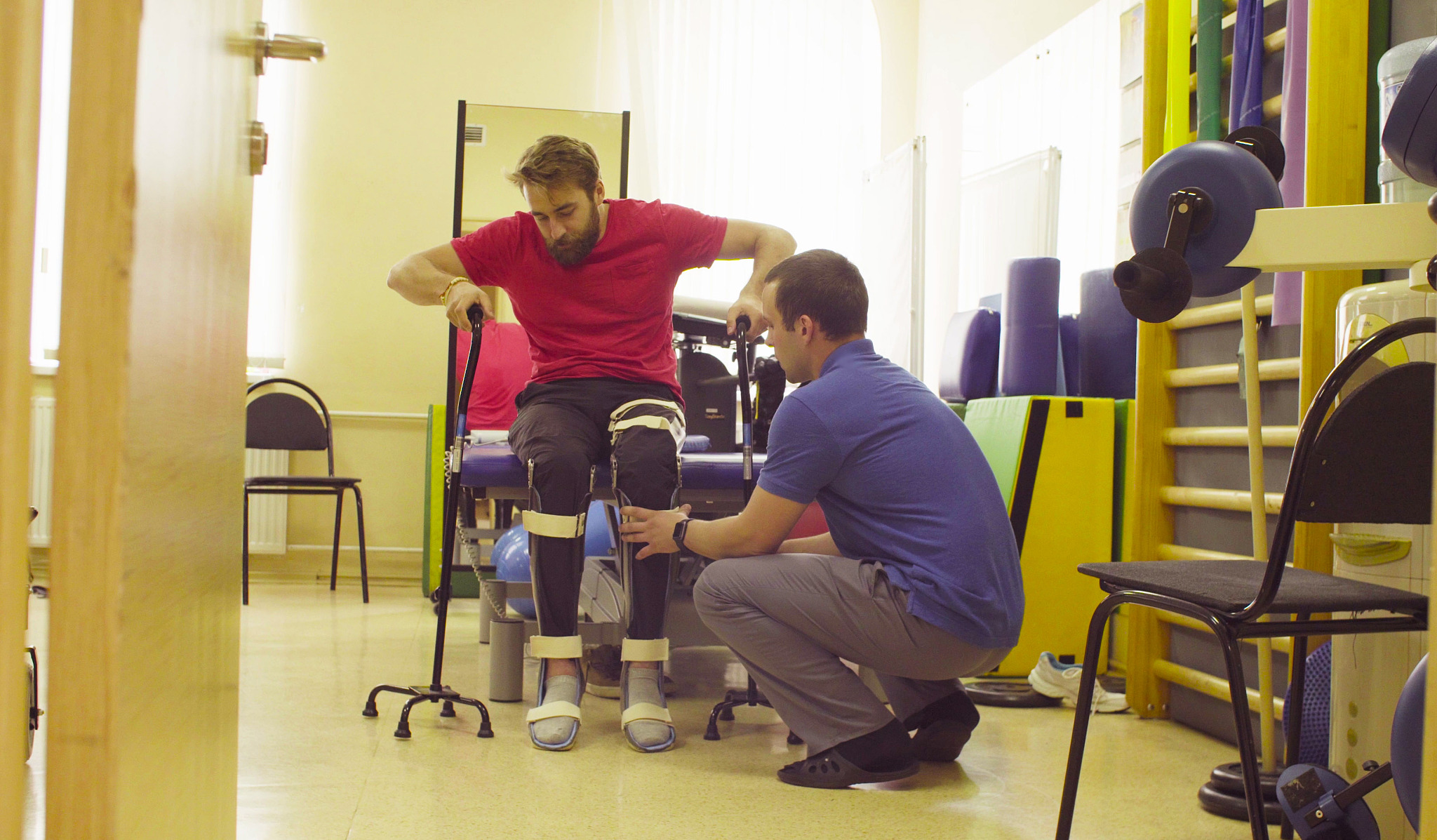 doctor physiotherapist putting the orthosis for disabled man
