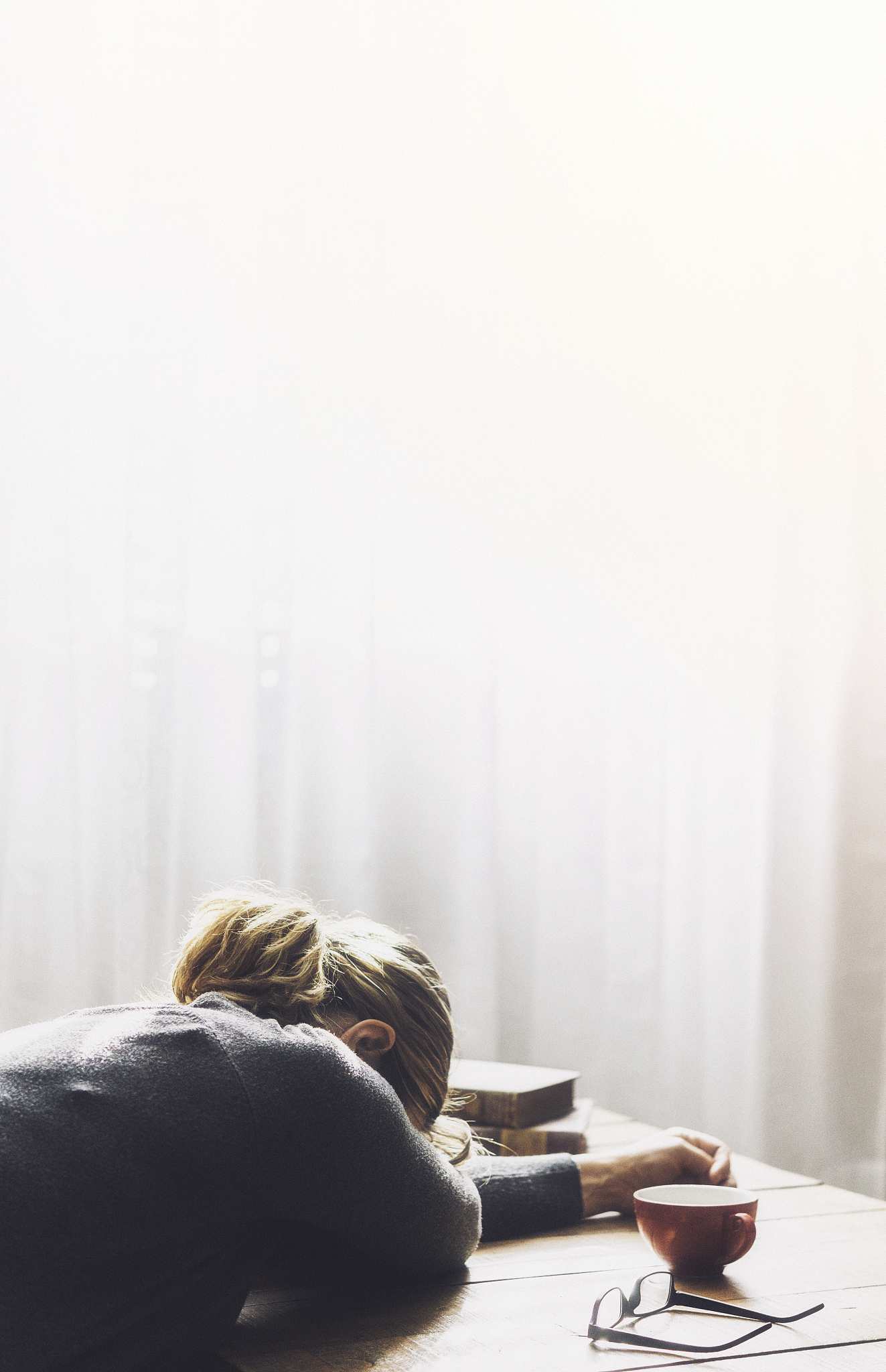 stressed woman sitting in loft surrounded by bright sunlight