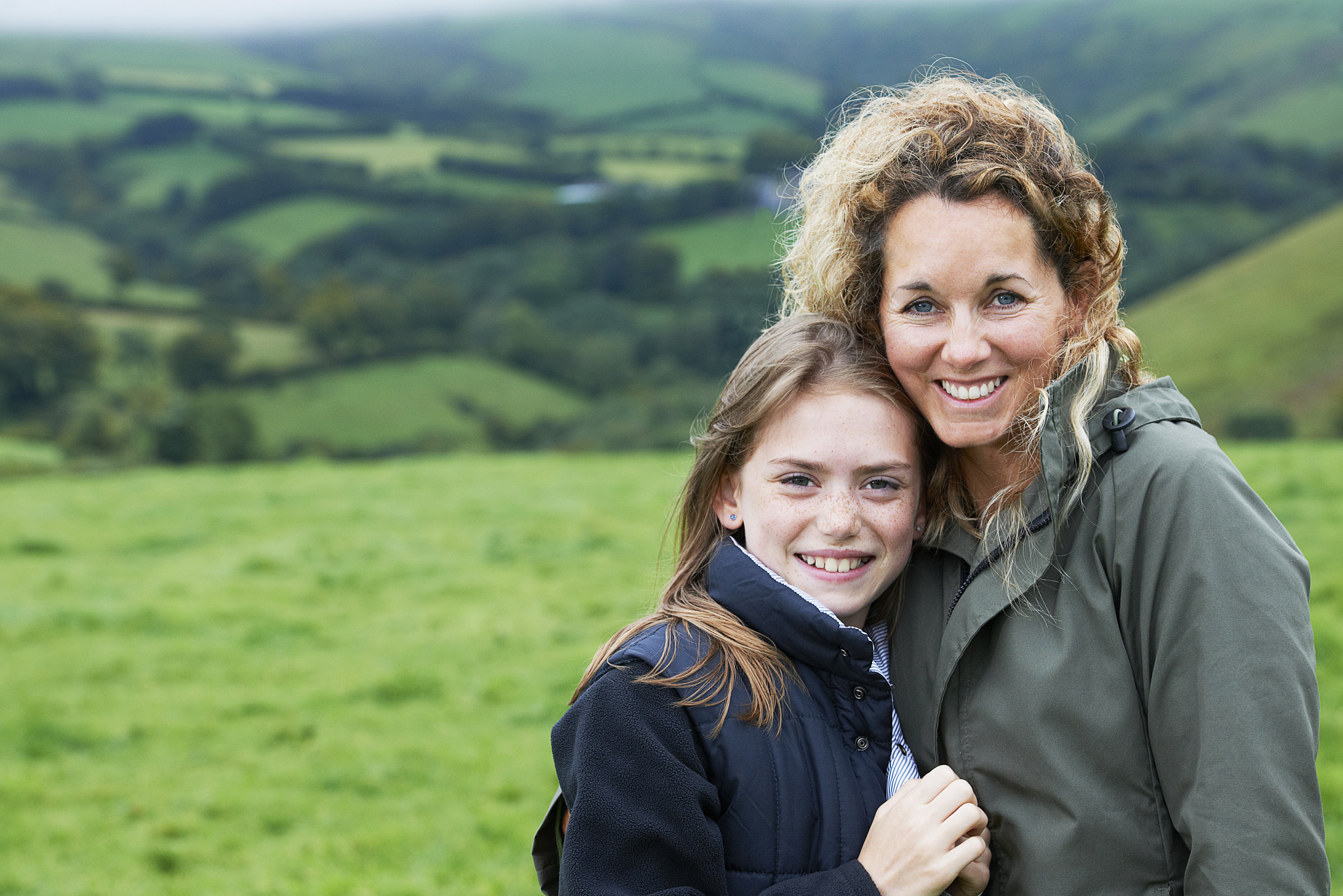 mother and daughter hugging in field