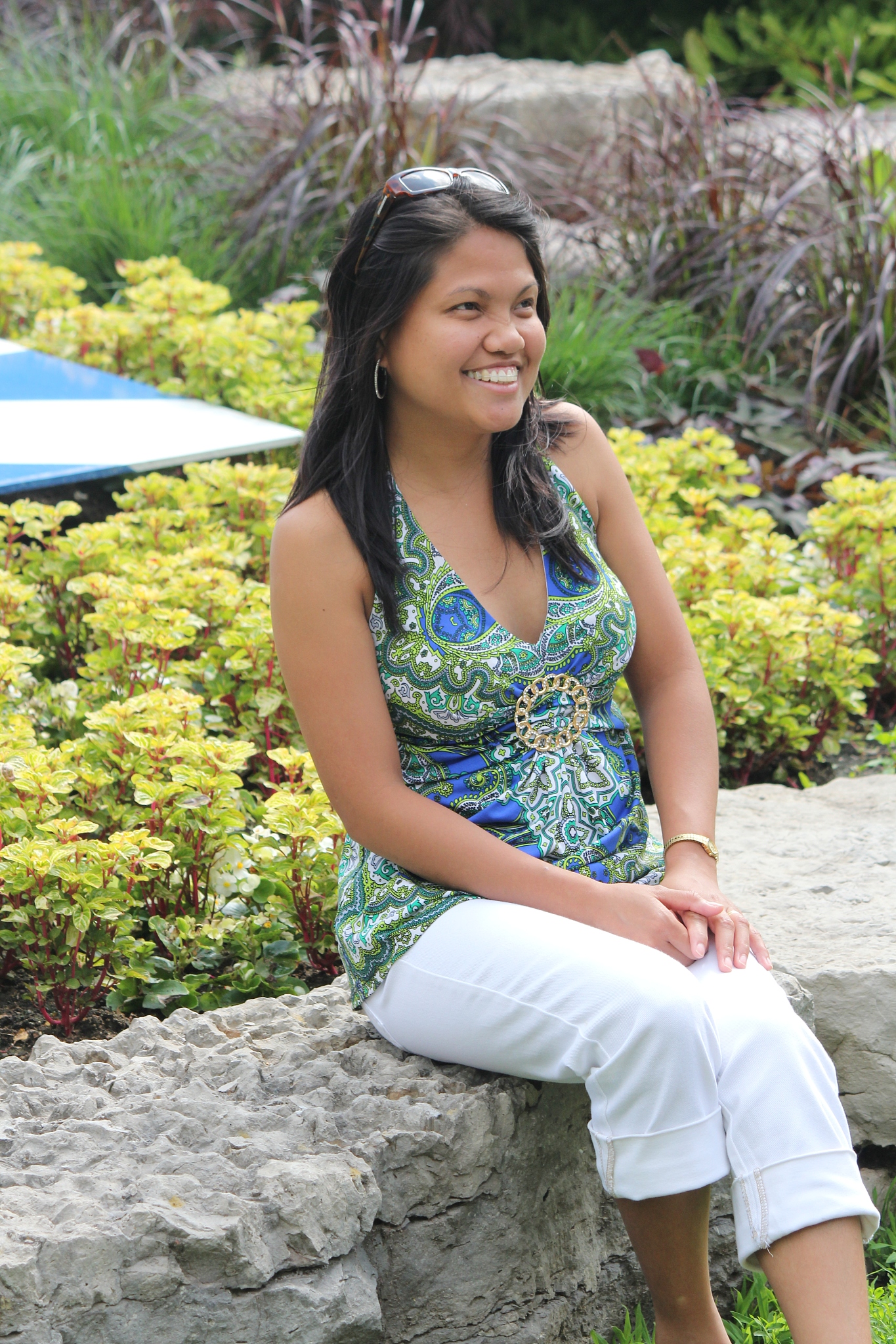 girl sitting on stone wall in park
