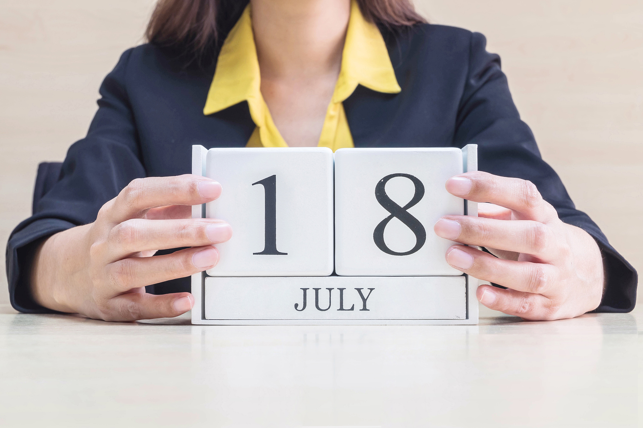 closeup white wooden calendar with black 18 july word in blurred