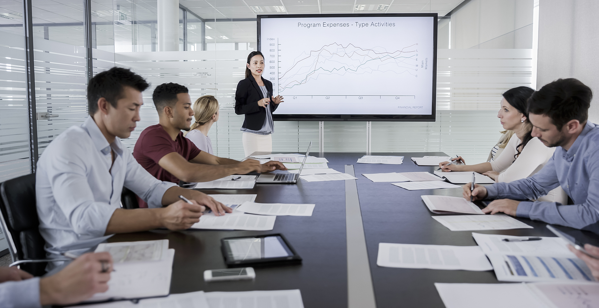 woman explaining financial report details to colleagues