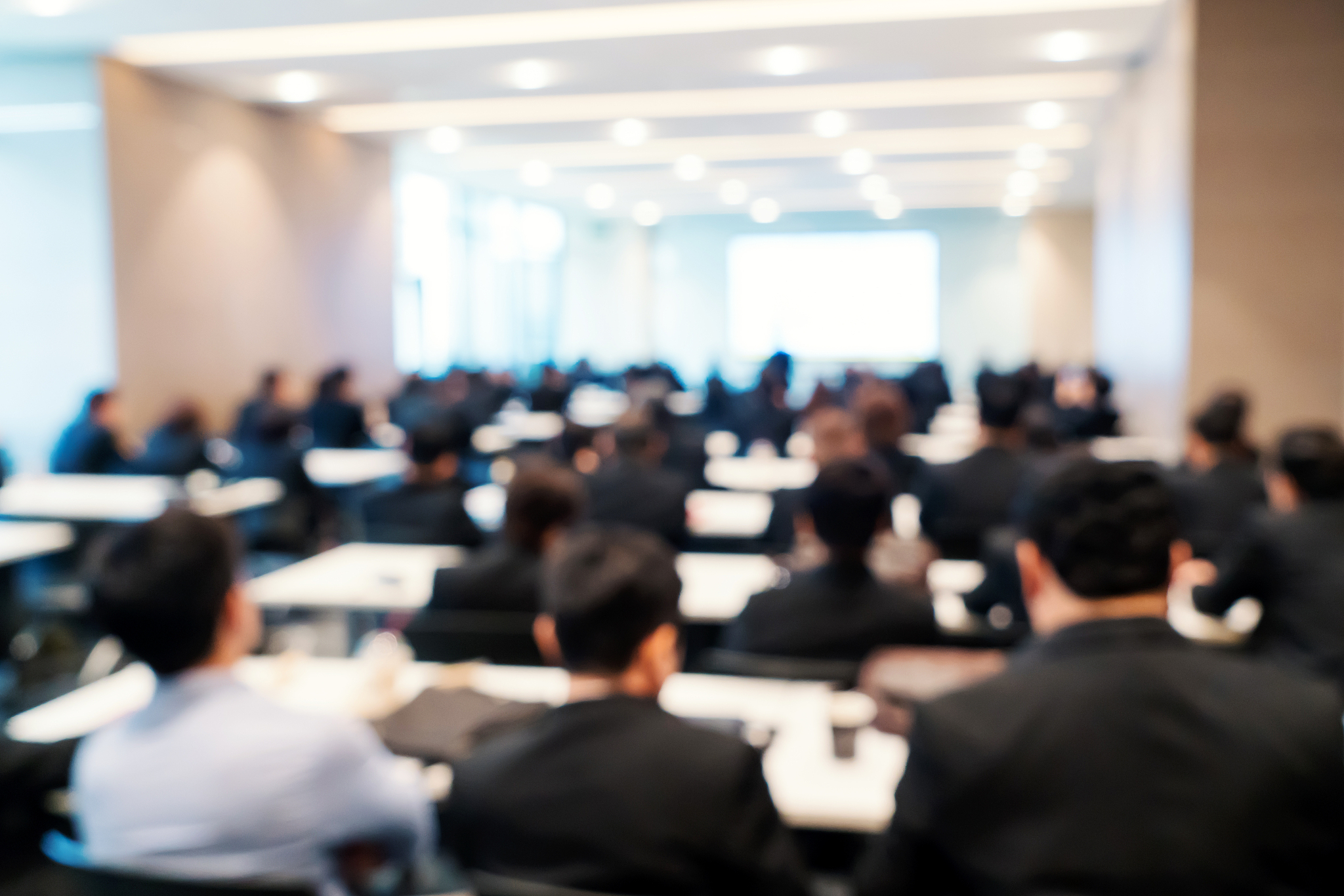 abstract blurred of speakers on the stage with business people o