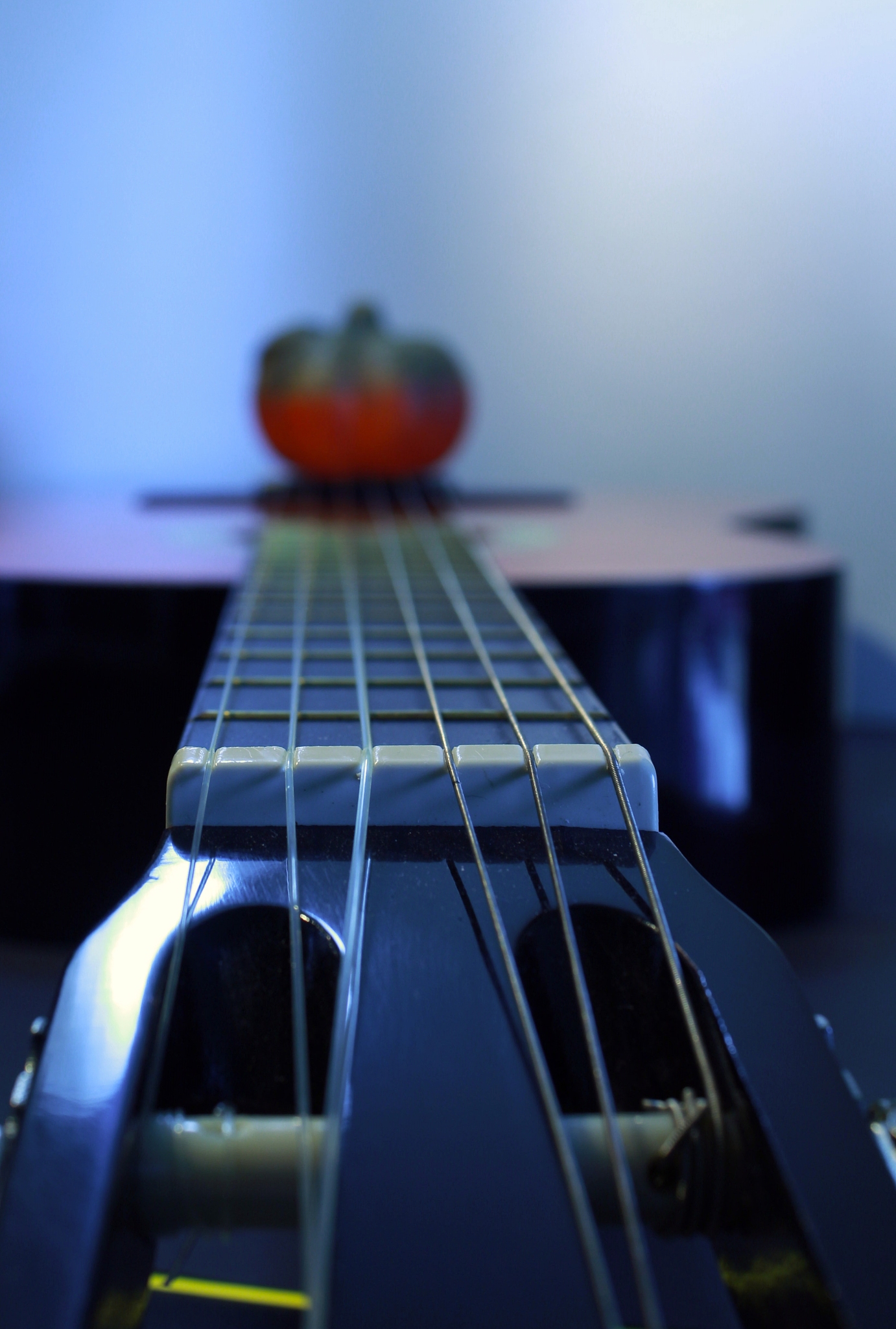 guitar saddle with the six strings and a pumpkin decoration on t
