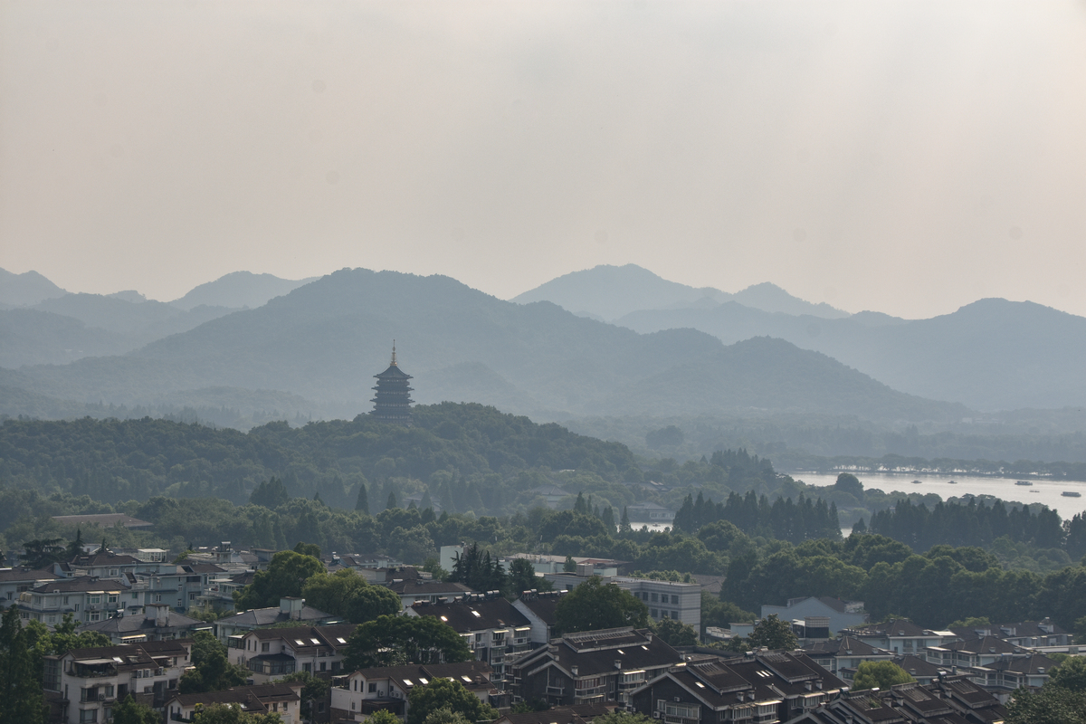 雾气笼罩下的<strong>杭州</strong>屋顶和雷峰塔,远景为山脉