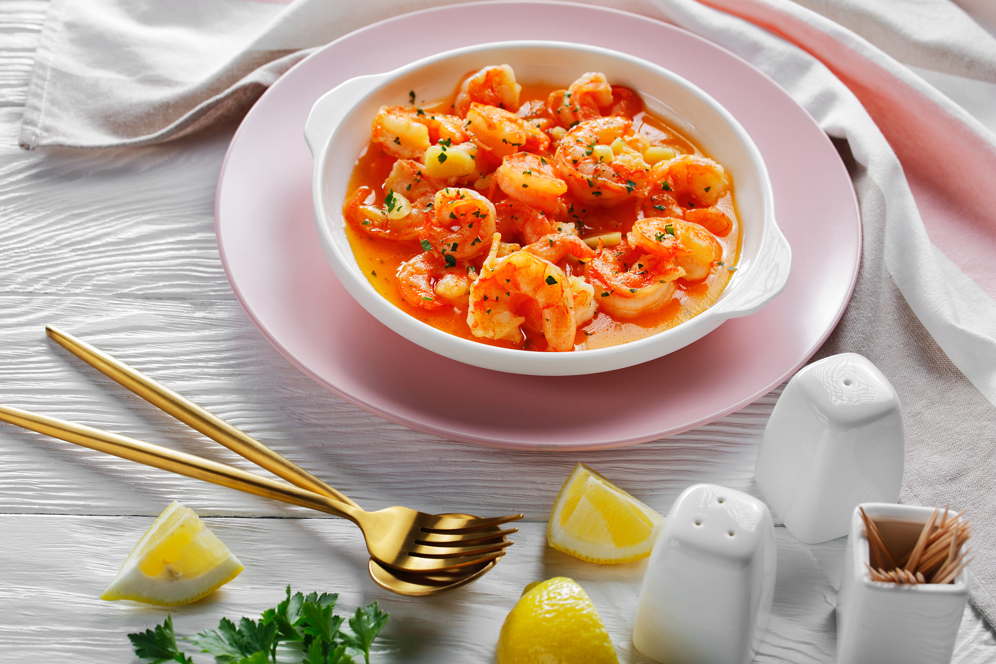 shrimp scampi with garlic butter sauce served with lemon and spr