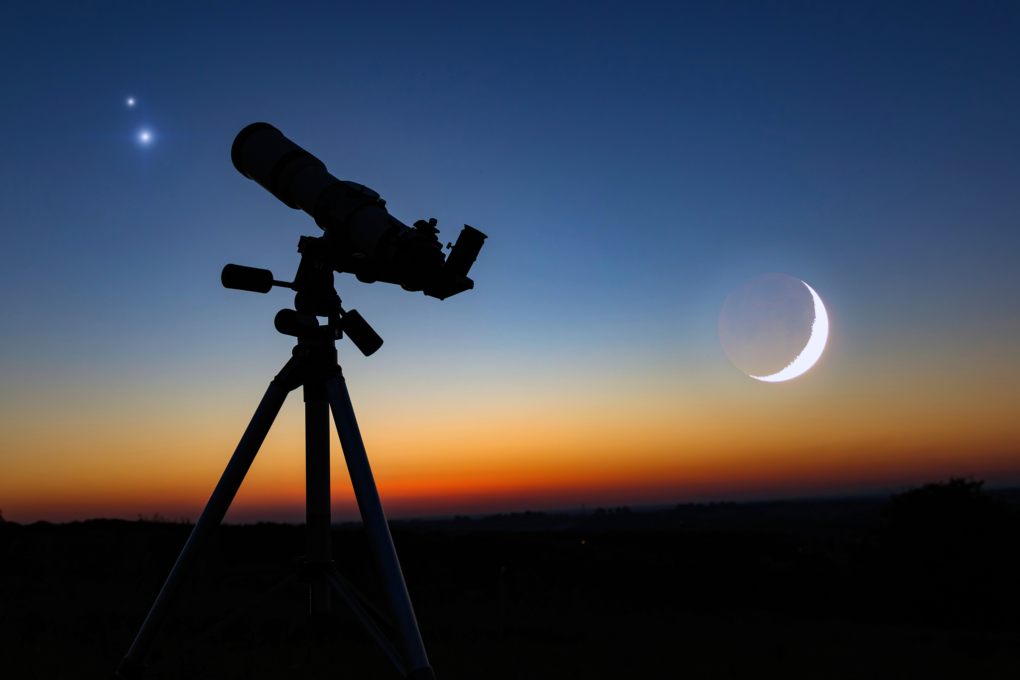 silhouette of a astronomy telescope with twilight sky.