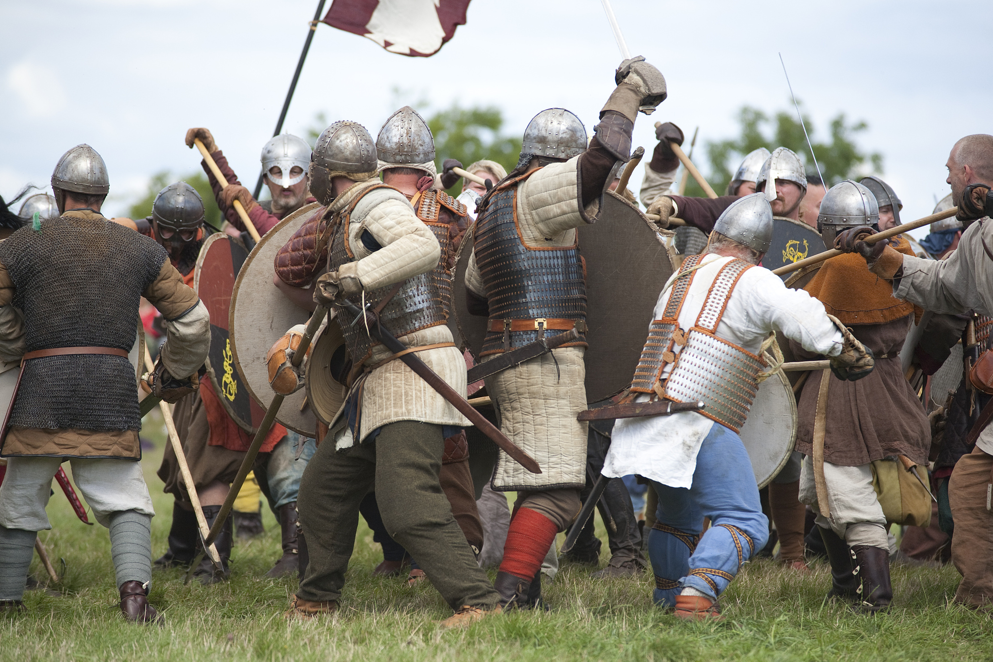 group of men dressed in viking costume play fighting, celebratio