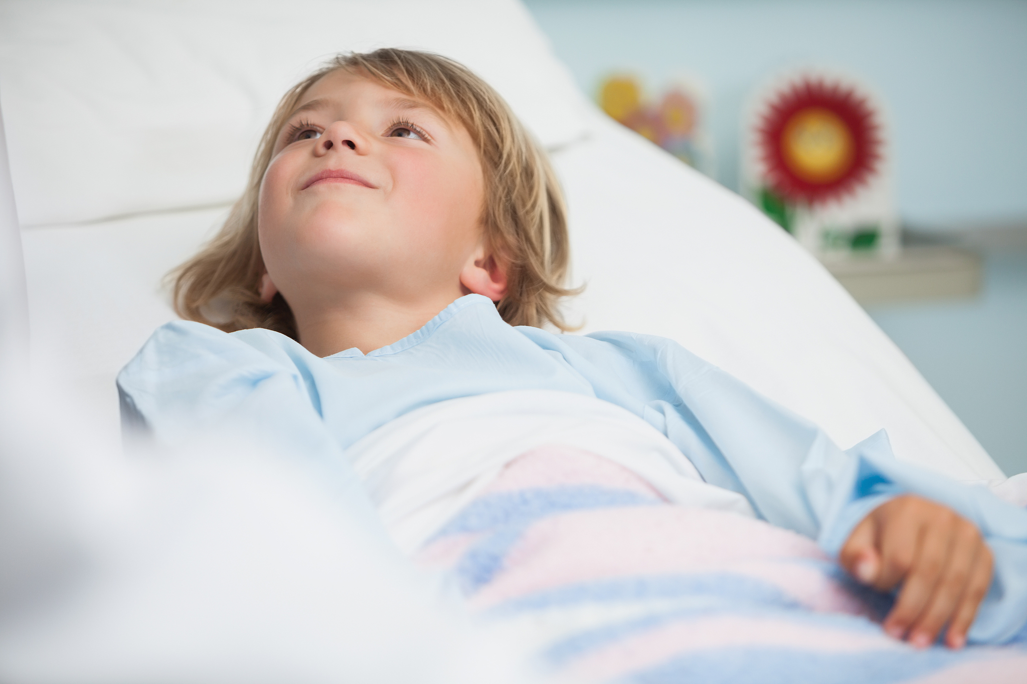 boy is lying in hospital bed