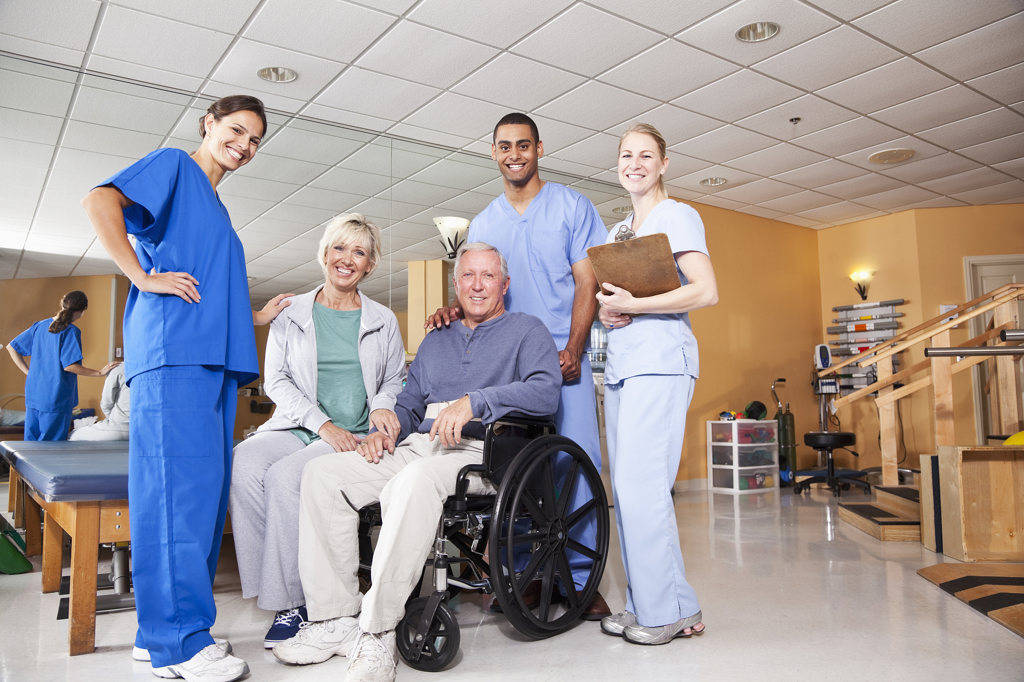 physical therapists with patient and spouse