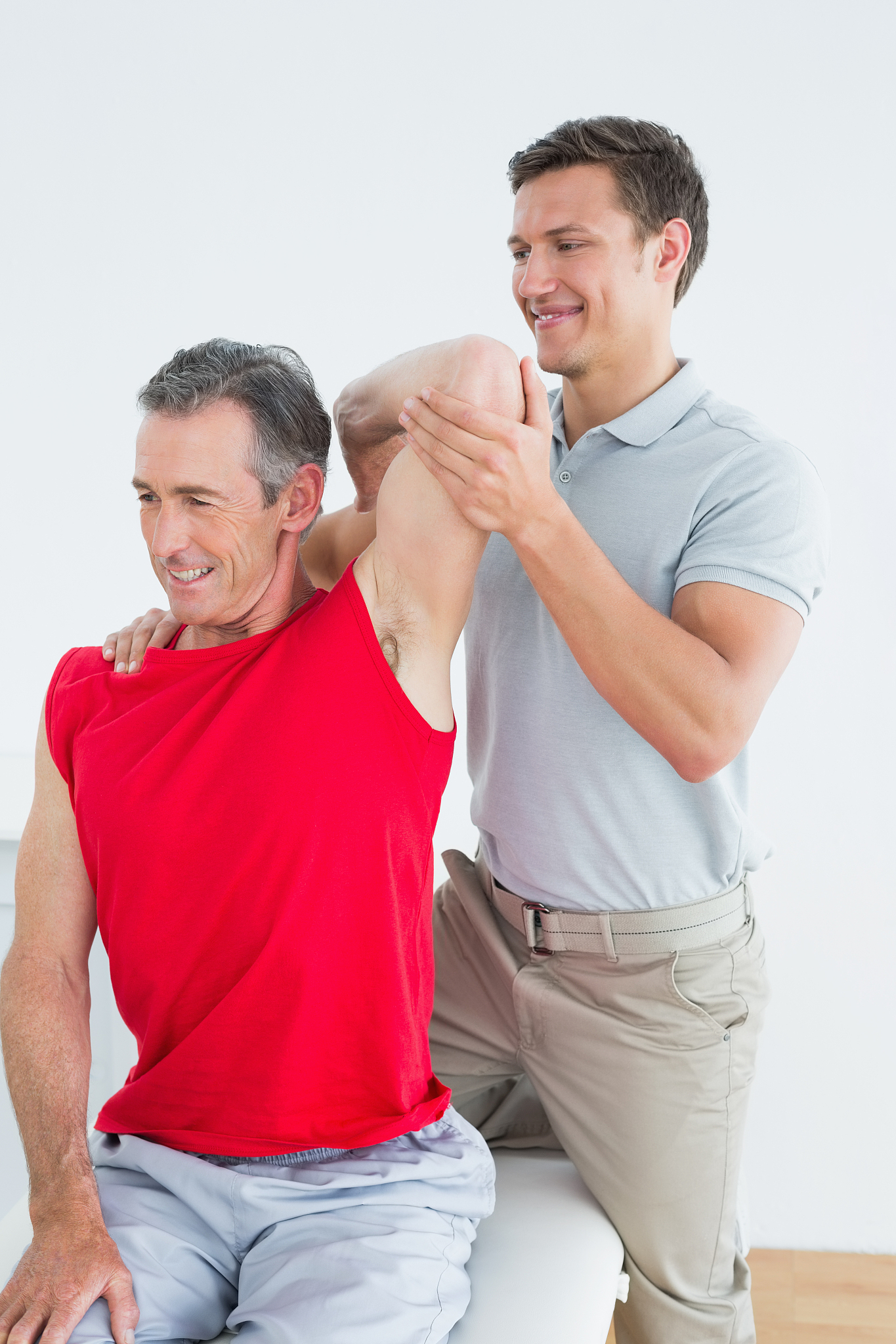 physiotherapist stretching a smiling mature mans arm