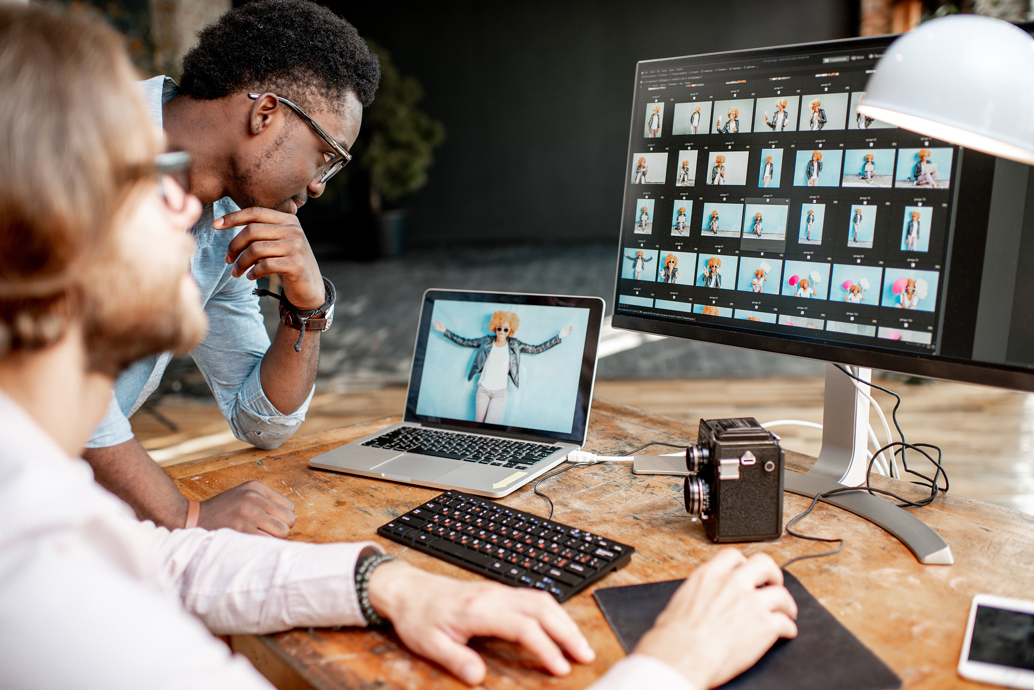 two photographers working on the computers in the studio