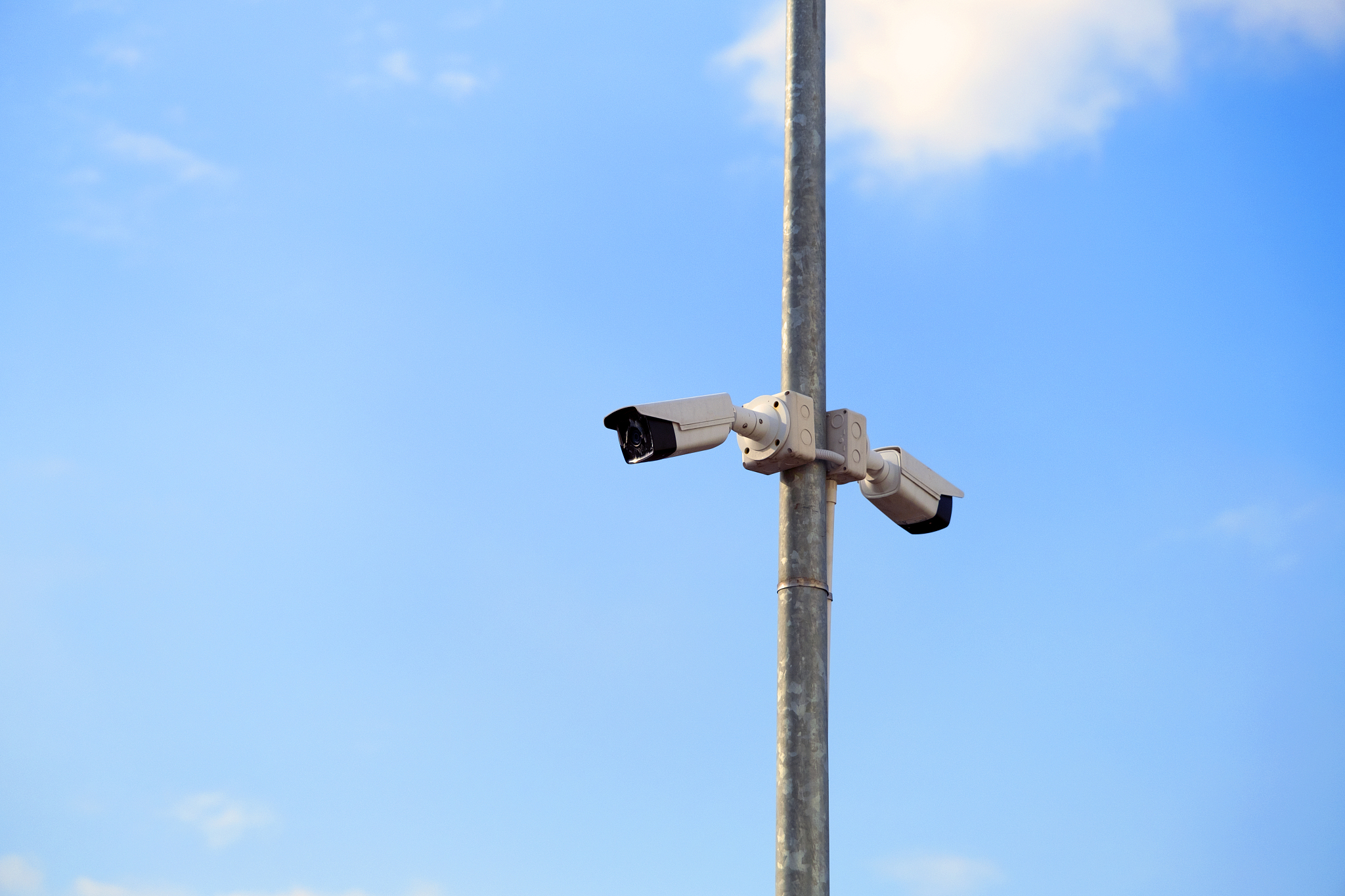 cctv camera mounted on a pole in the blue sky background
