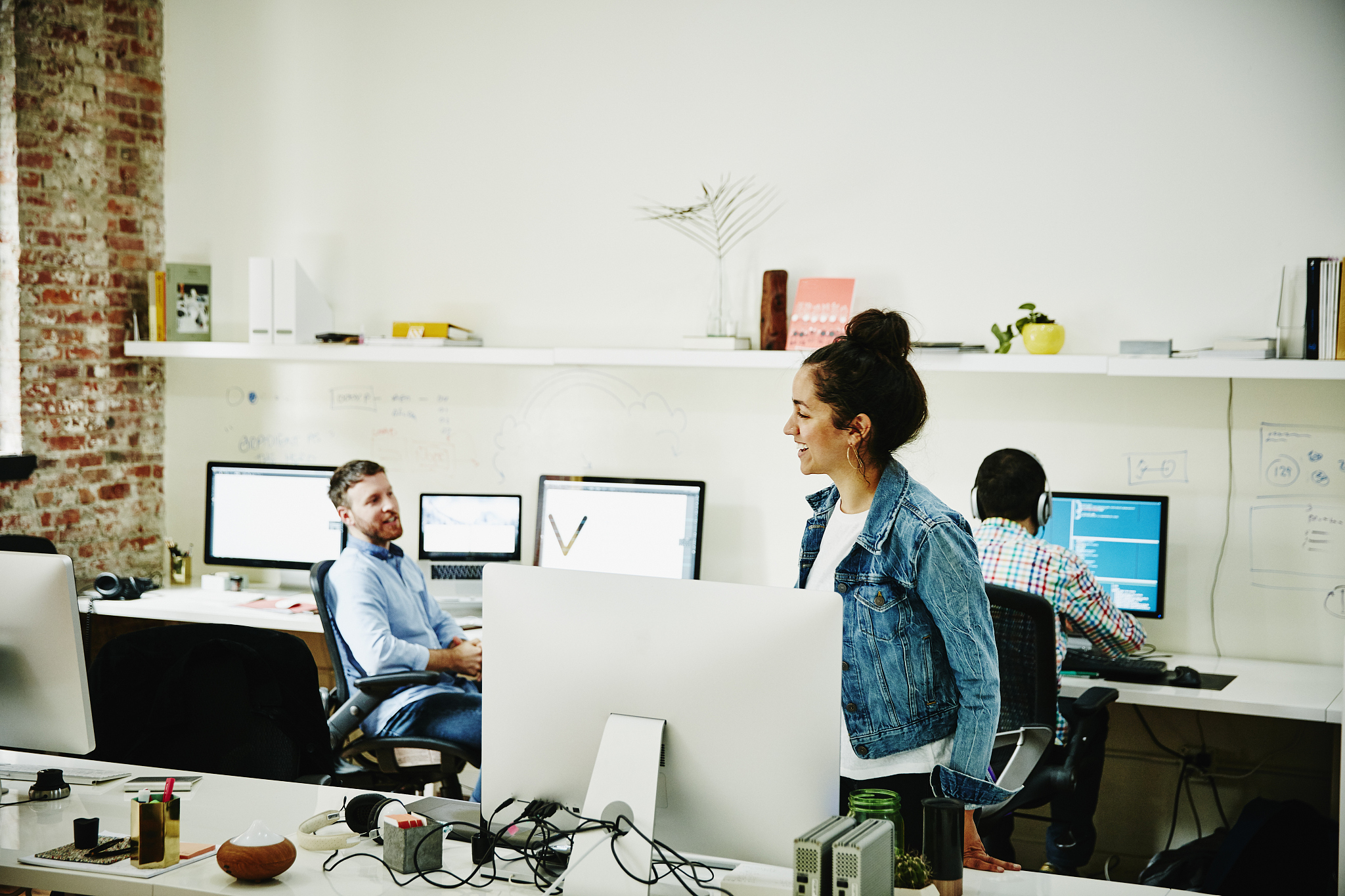 smiling designer in discussion with coworkers