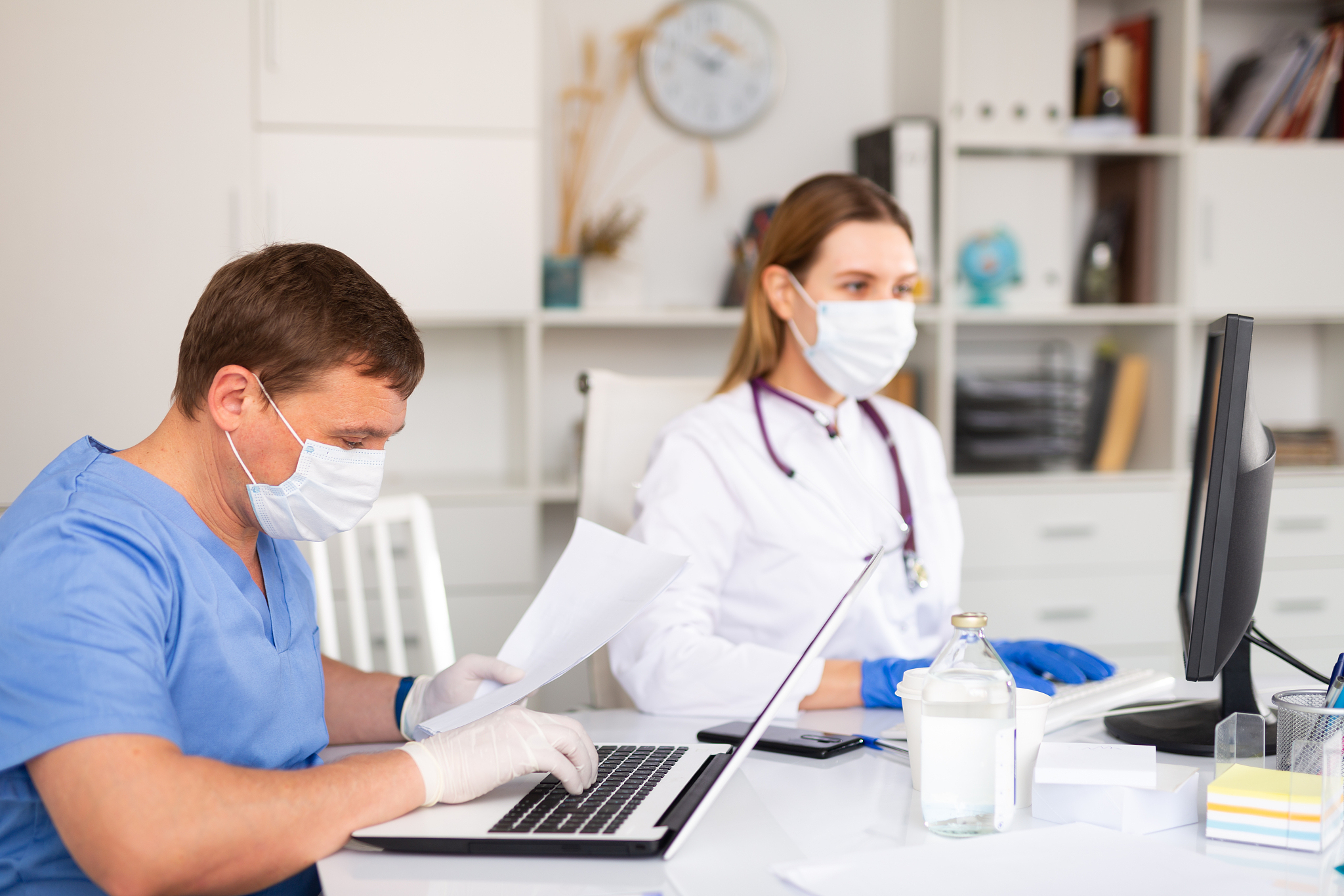 doctor and nurse in protective mask check patient data in hospit