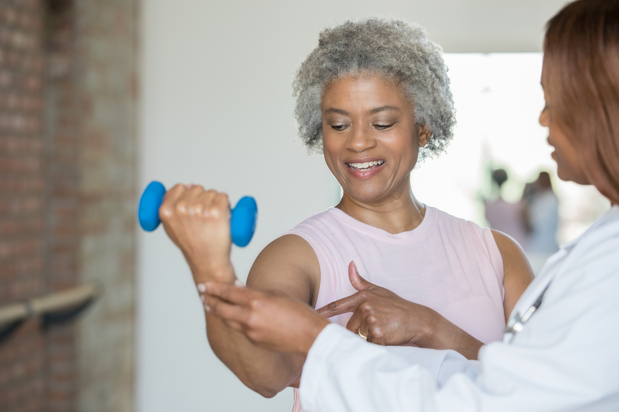 senior woman pointing at injury to show physical therapist