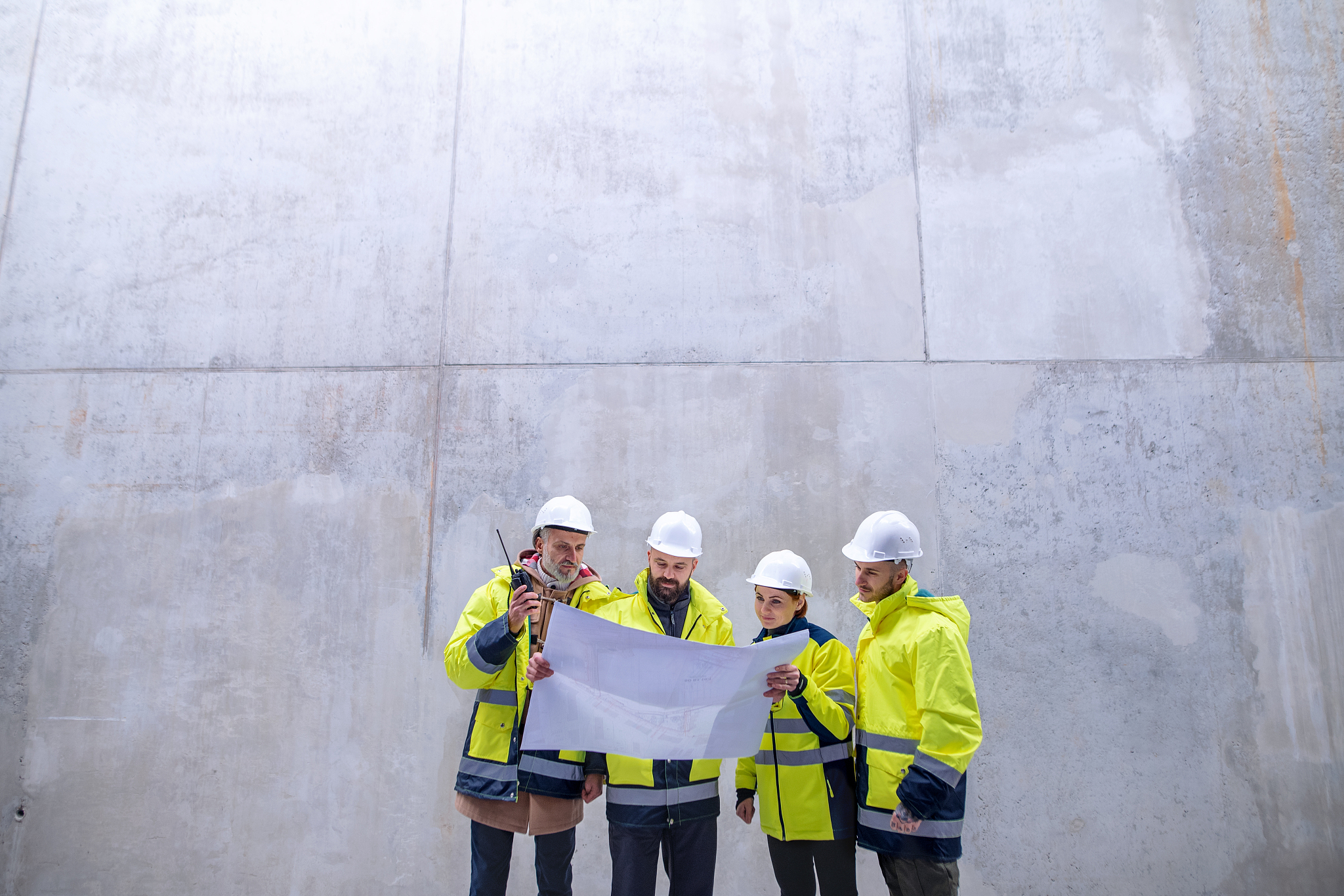 a group of engineers standing against concrete wall on construct