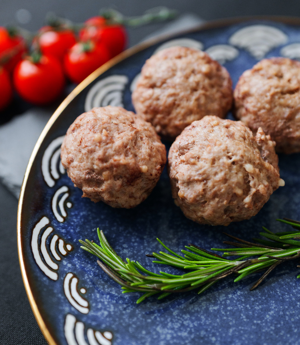 装饰蓝盘上的美味肉<strong>丸</strong>,饰以新鲜迷迭香和鲜红的樱桃