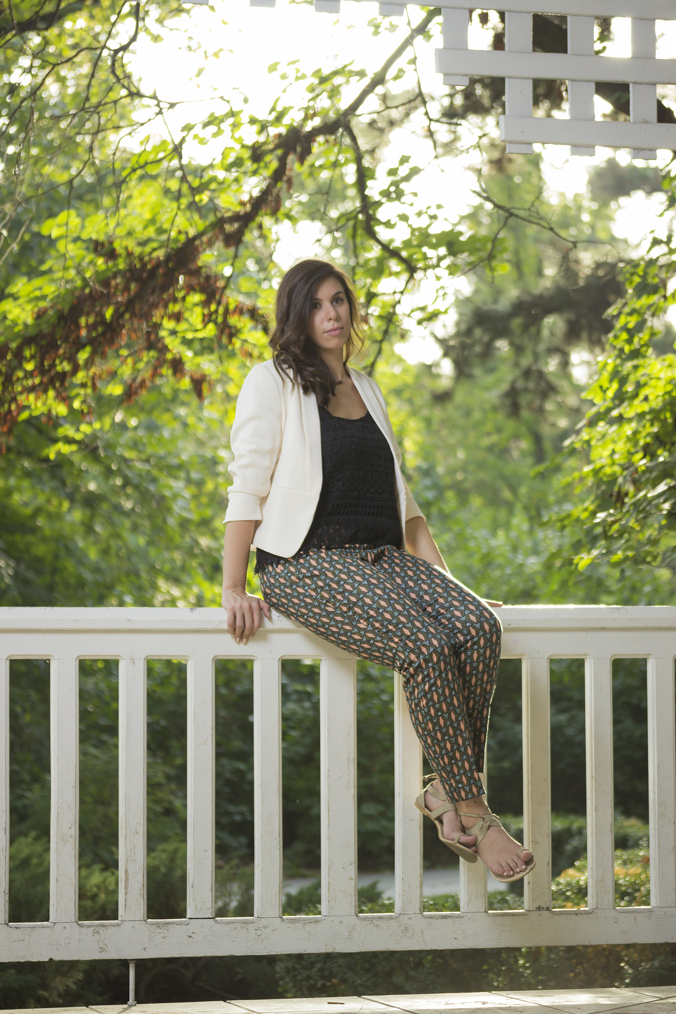 young elegant girl portrait in park, sitting on wooden fence.