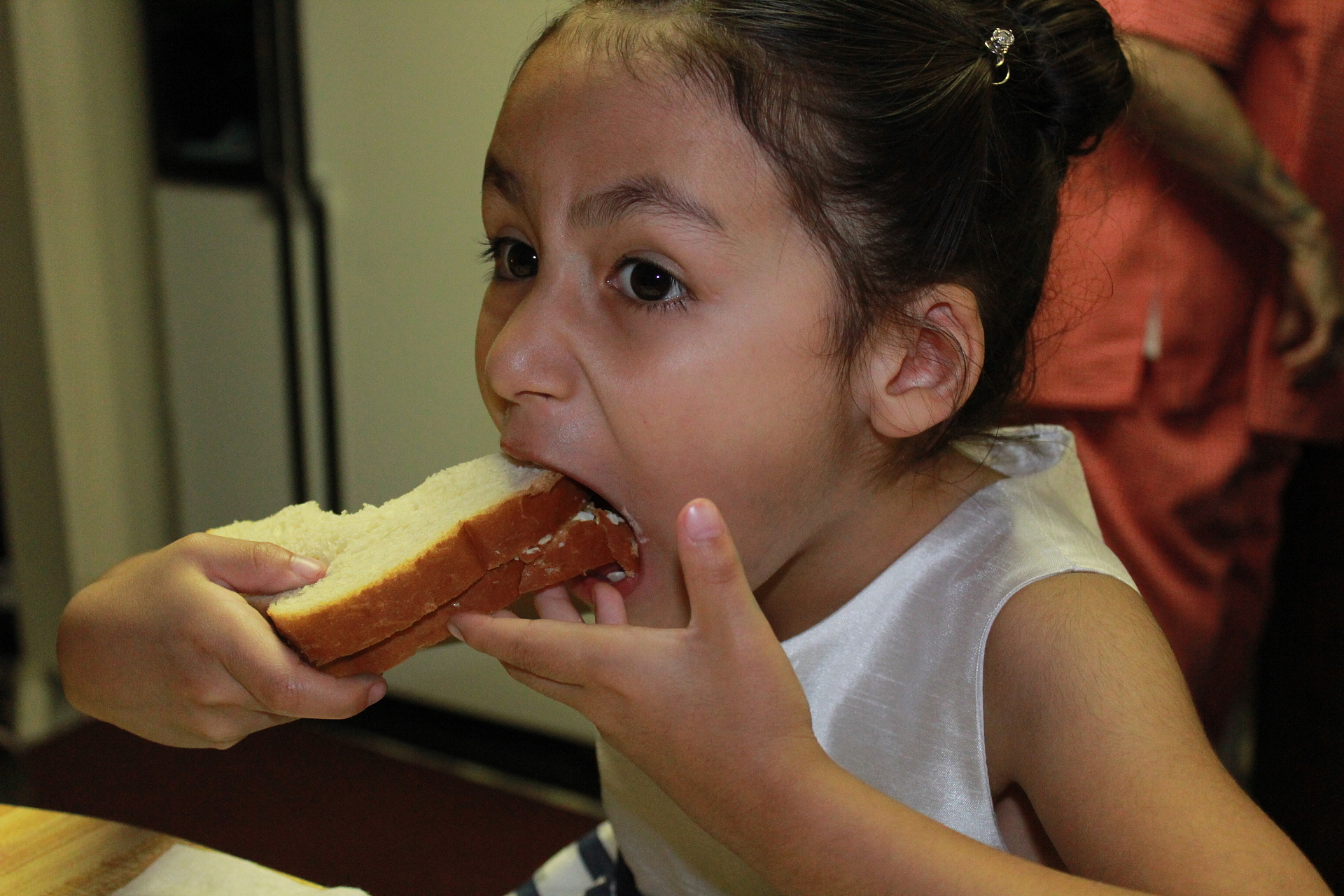 girl eating bread at home