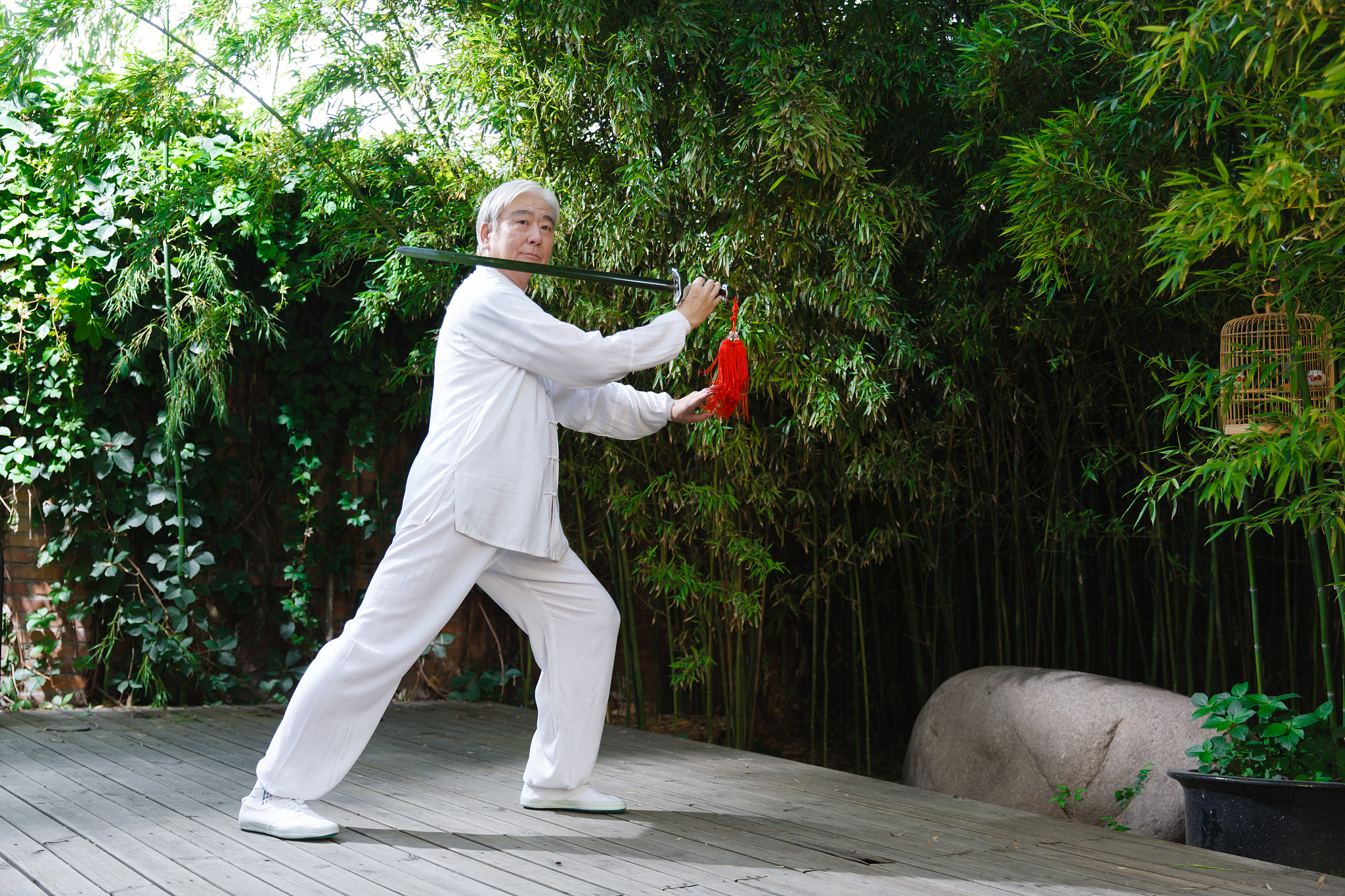 一个老年男人拿着剑在练太极拳