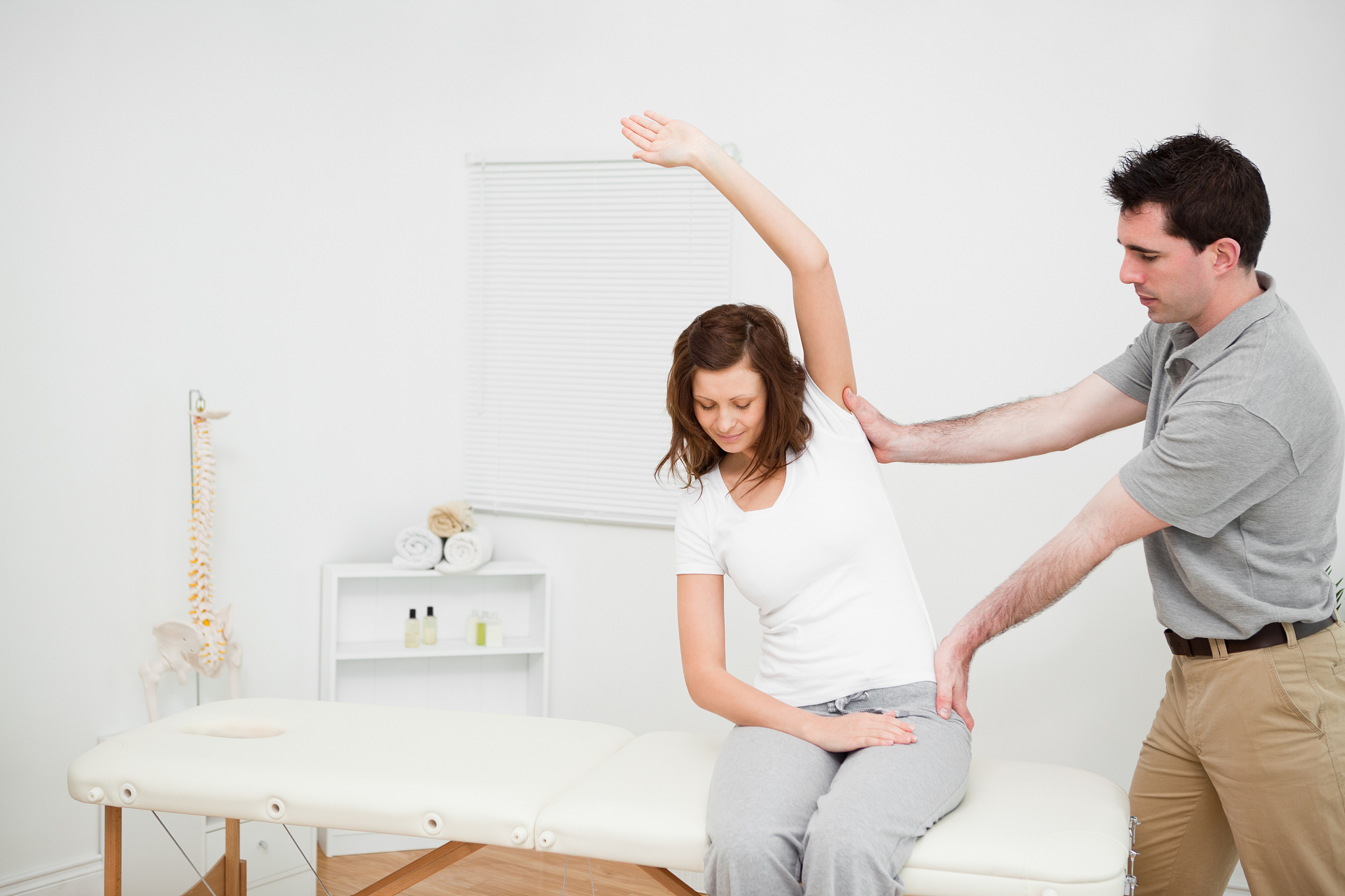 physiotherapist insuring central alignment of spine