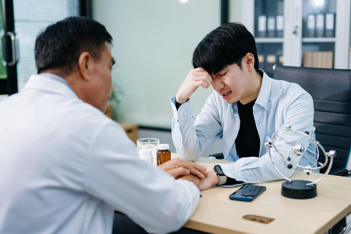 年轻的亚洲男性在办公室里与心理医生讨论心理健康.,,