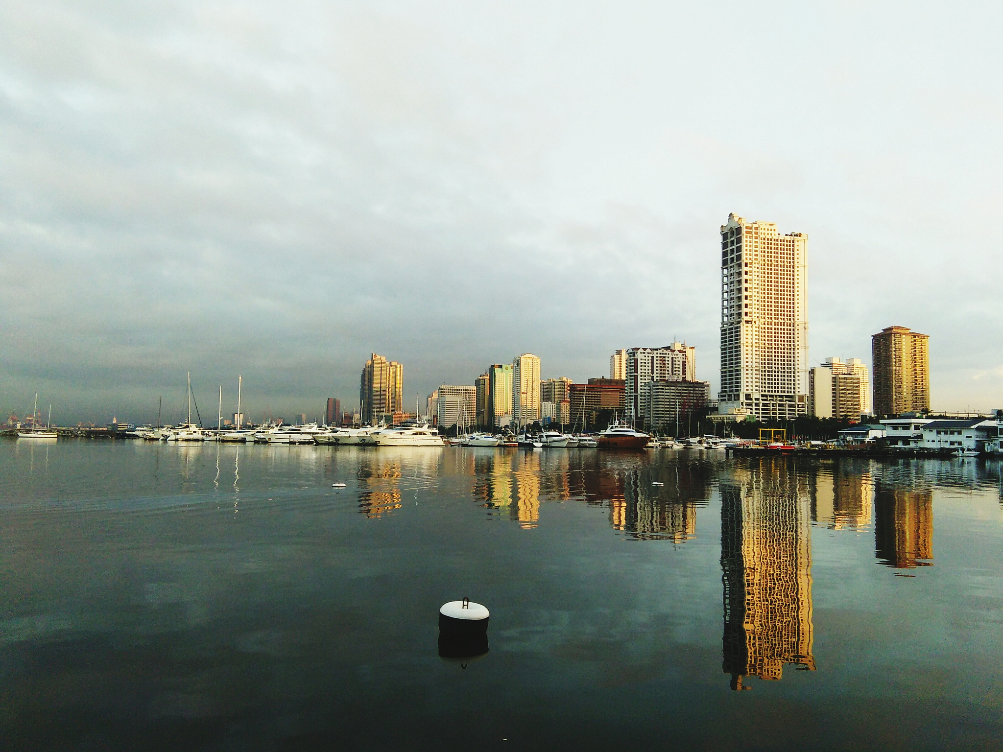 city at waterfront against cloudy sky