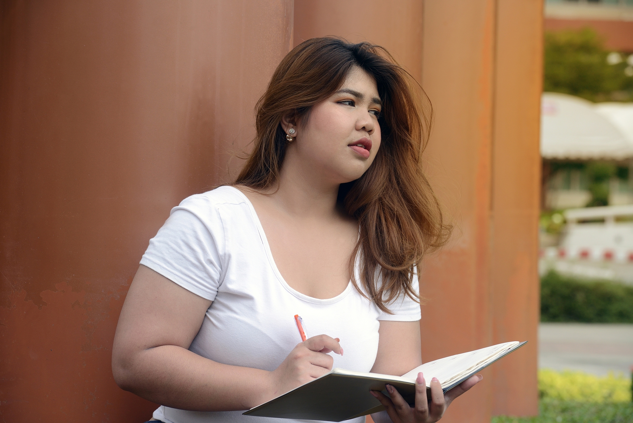 young woman holding book by columns