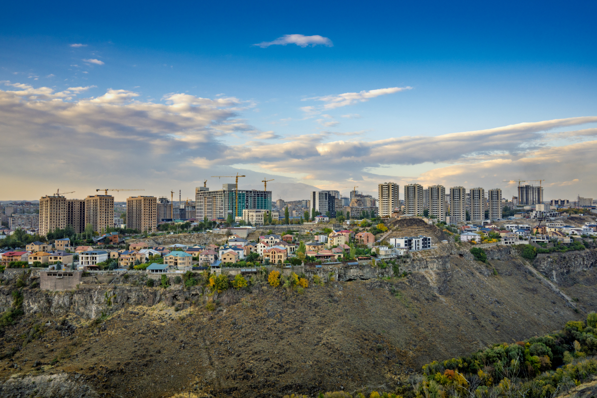 一座城市,有很多建筑,背景有一座小山