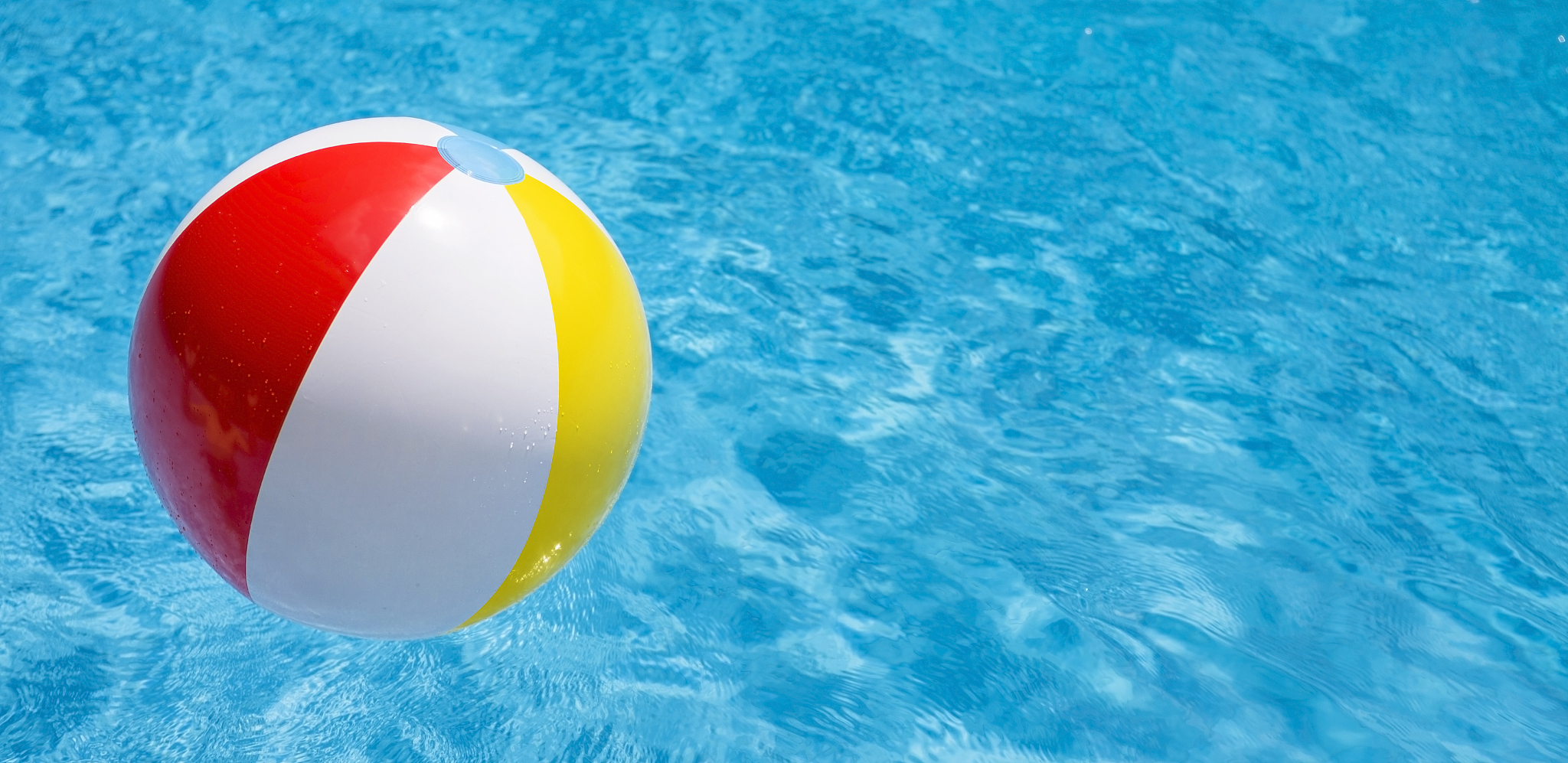 beach ball party in a blue water swimming pool