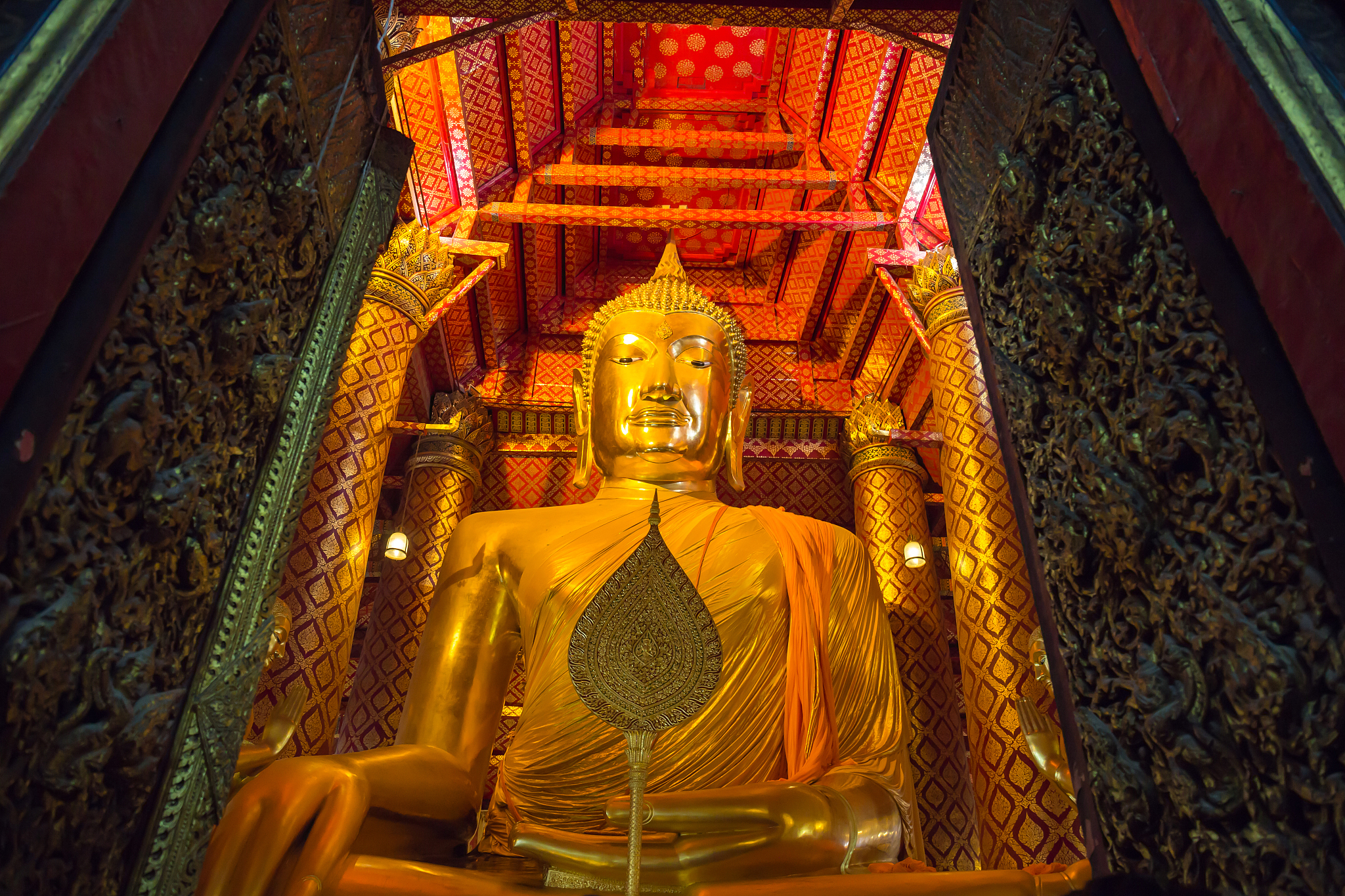 big golden buddha statue in temple at wat phanan choeng
