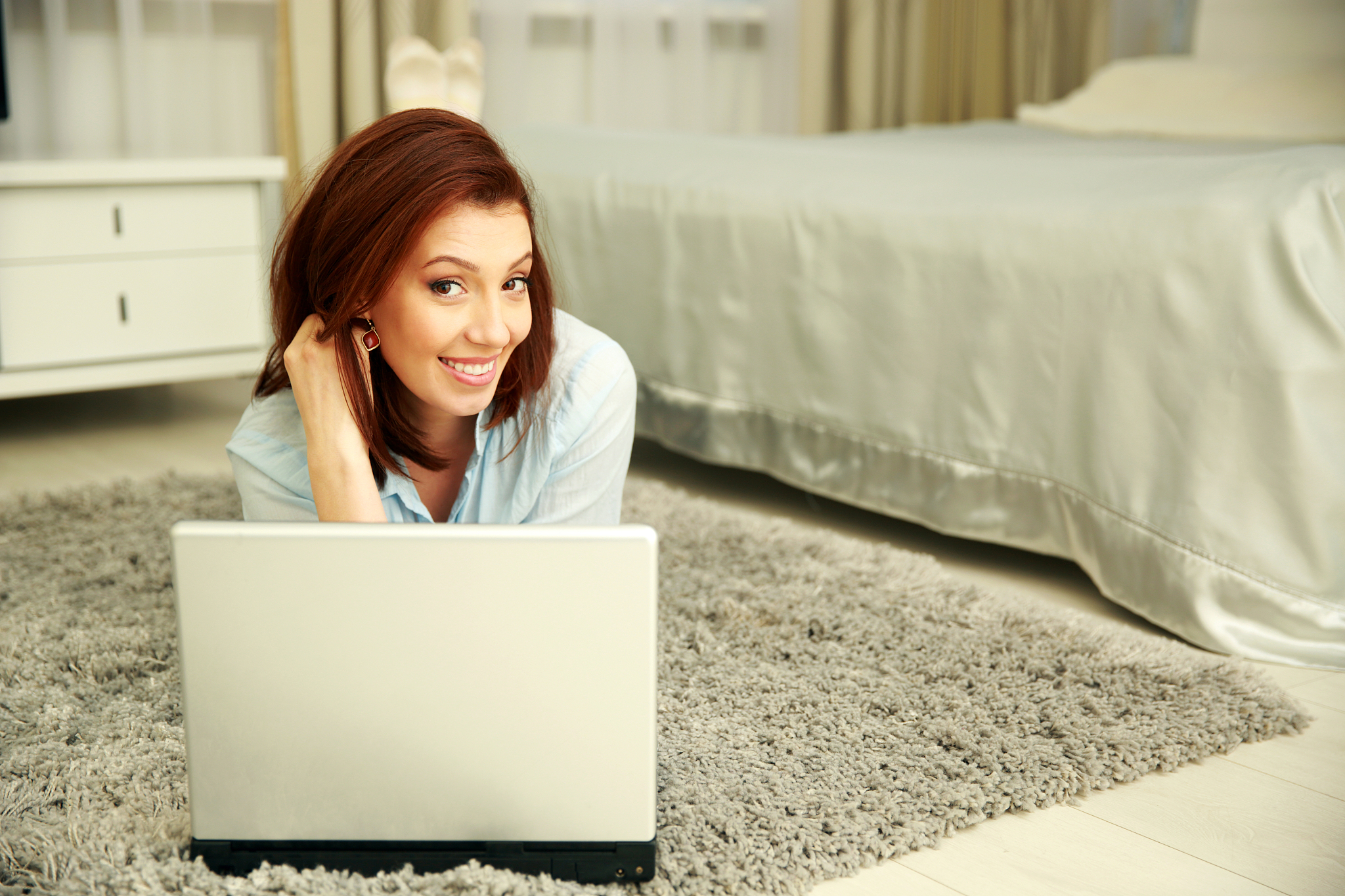 happy woman lying on the floor with laptop
