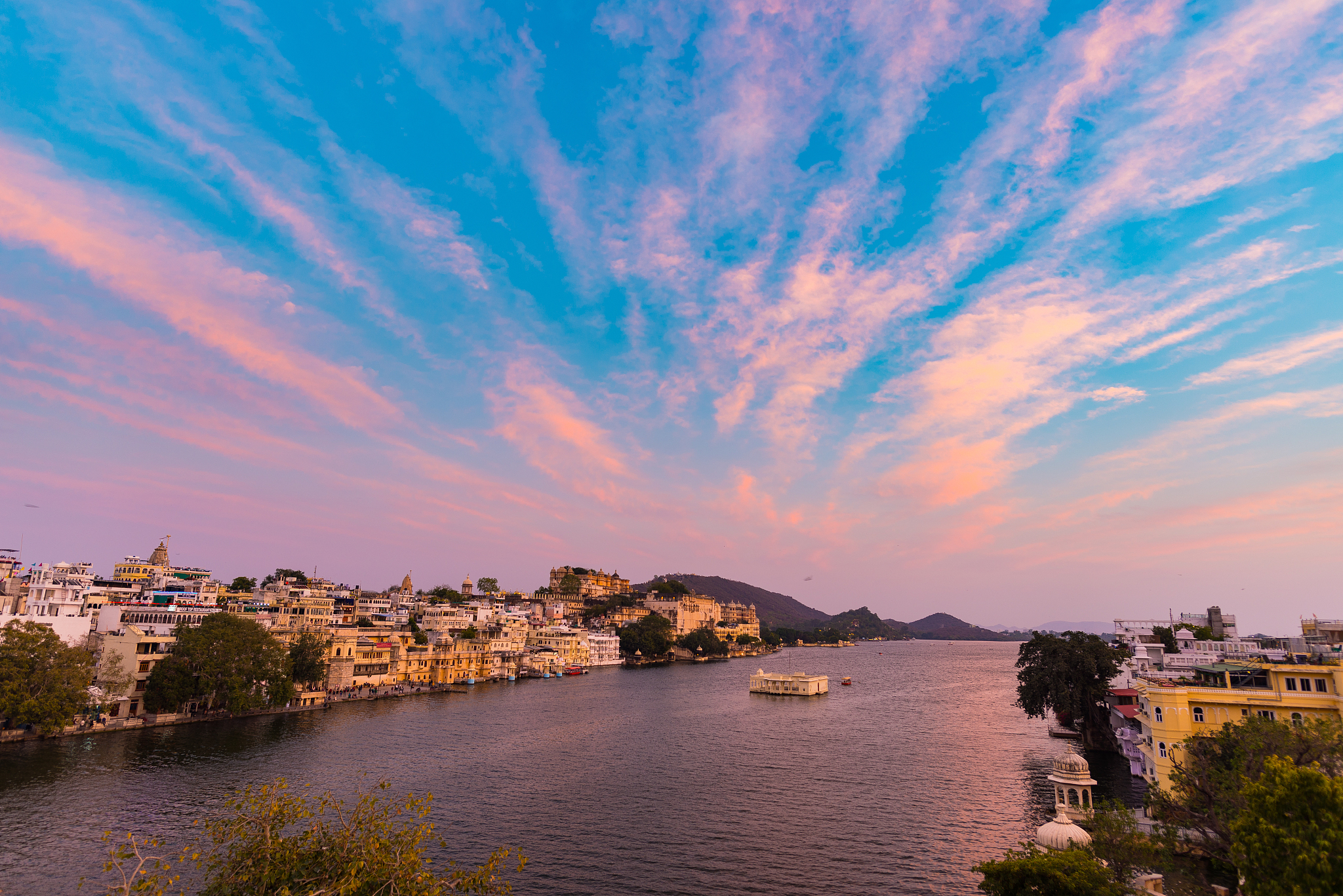 view of town by river against cloudy sky