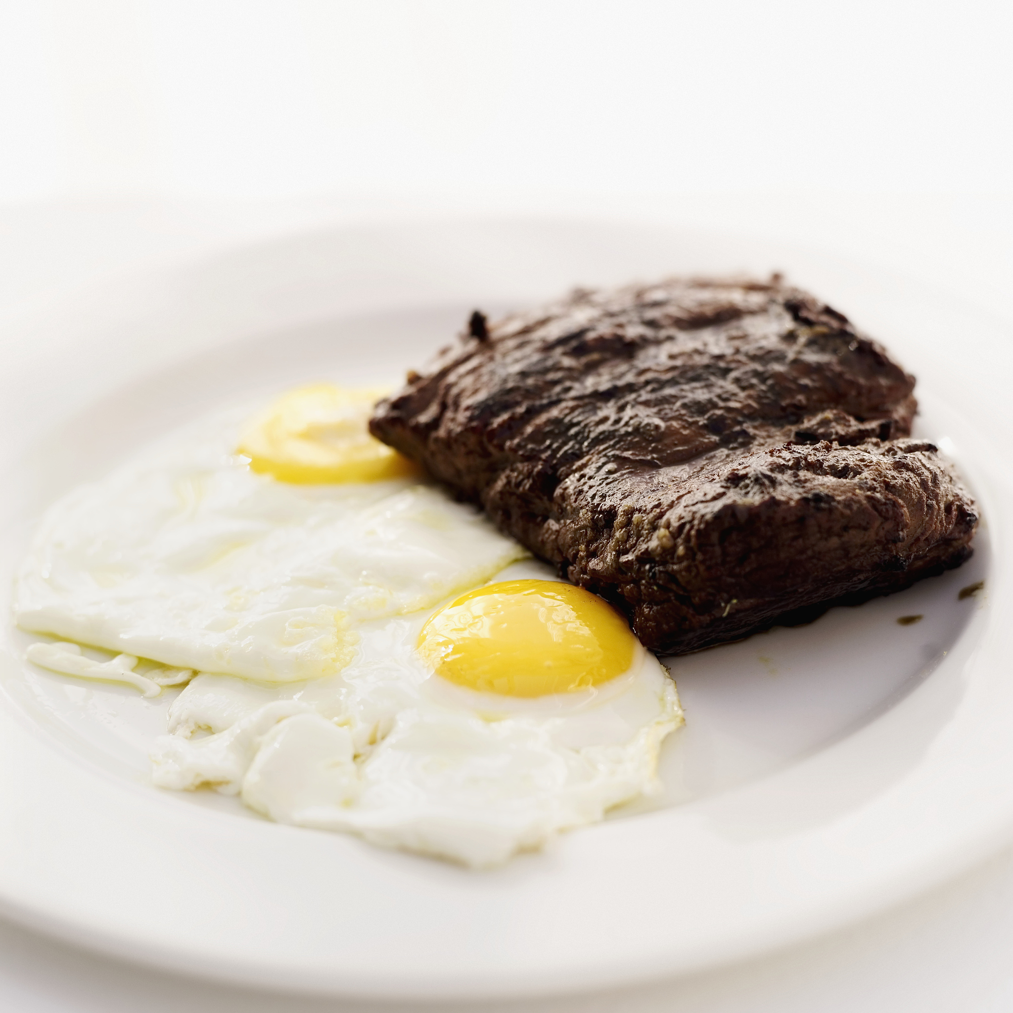 close-up of a steak served with fried eggs
