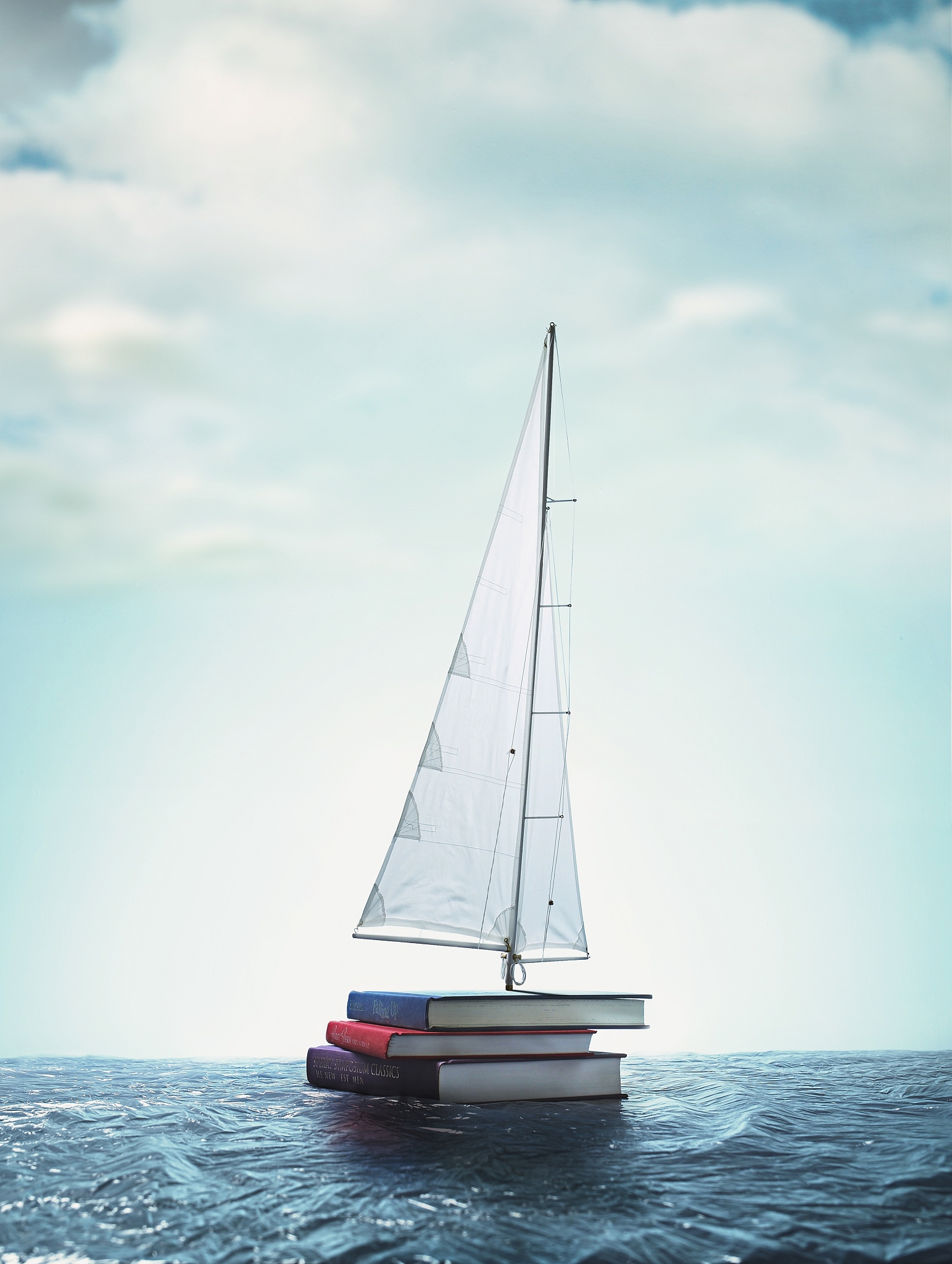 three books with a sail floating on the ocean