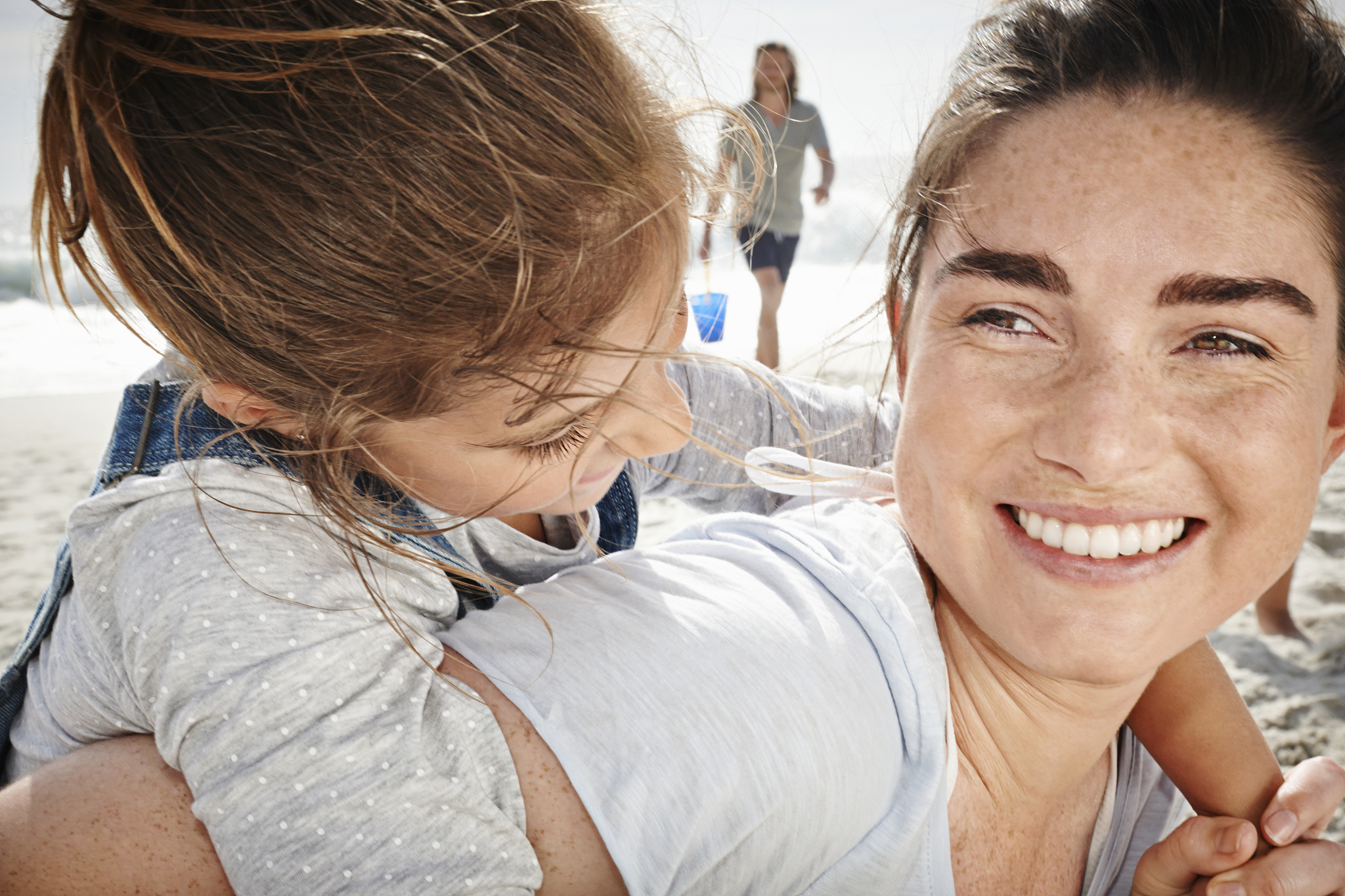 mother and daughter embracing, close up