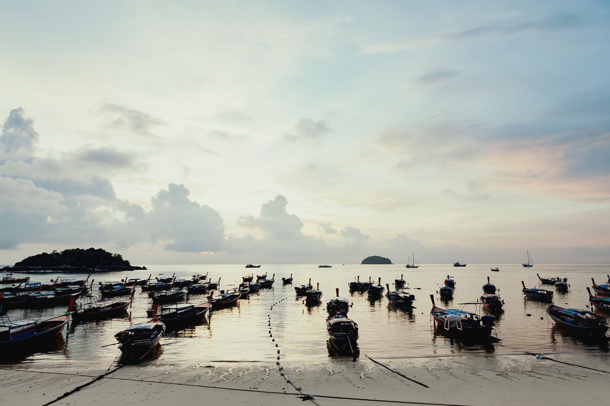 beautiful sea and beach with over group of long tail boats.